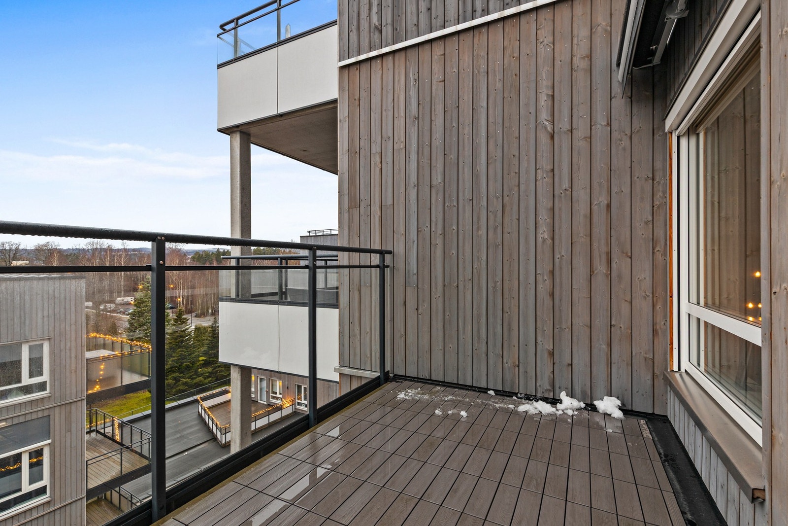 Det er lagt PVC flis på gulv og rekkverket består av glass og stål Galleribilde