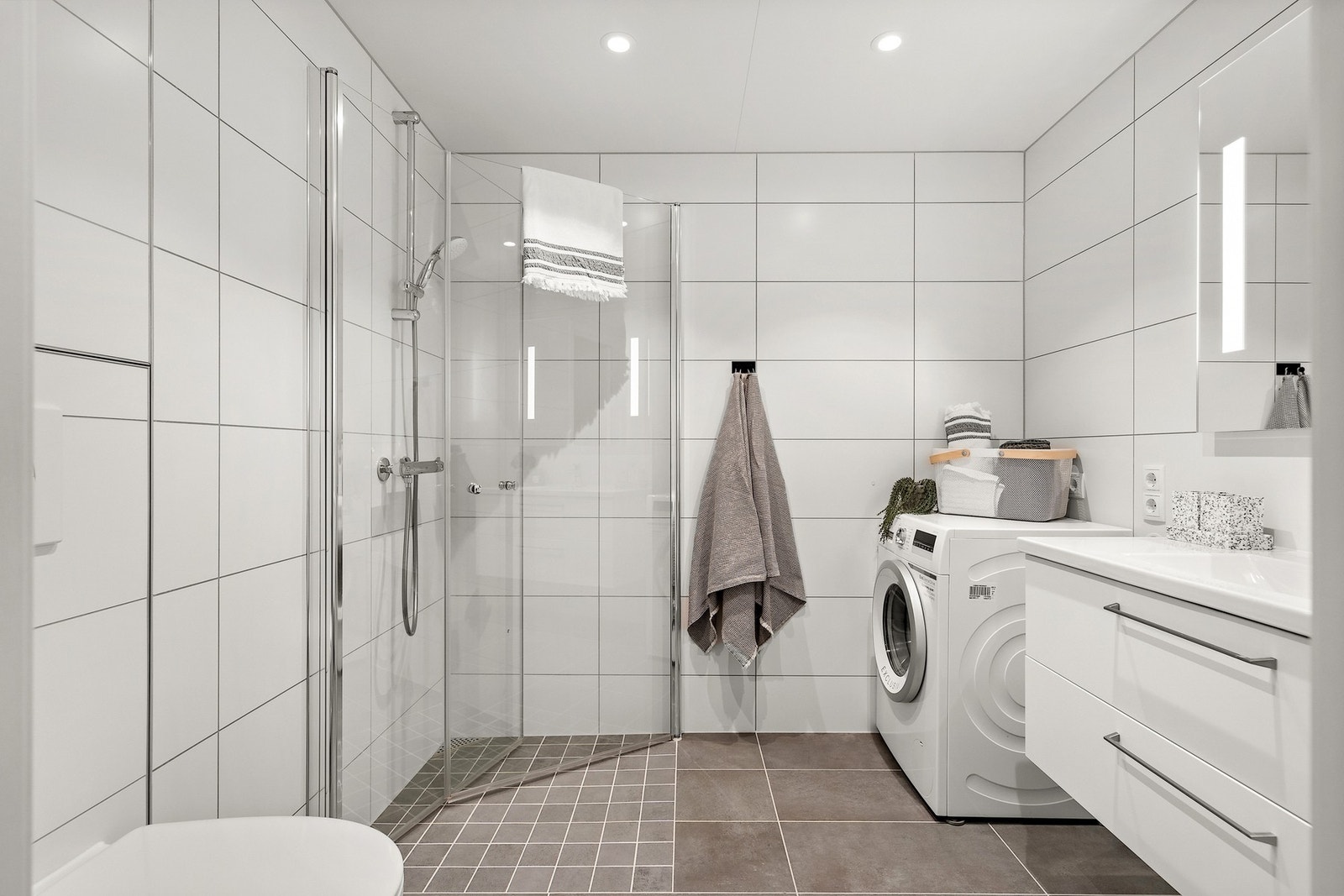 Badet holder en moderne og tidløs standard, med flislagte overflater og varmekabler i gulv som gir god komfort. Galleribilde