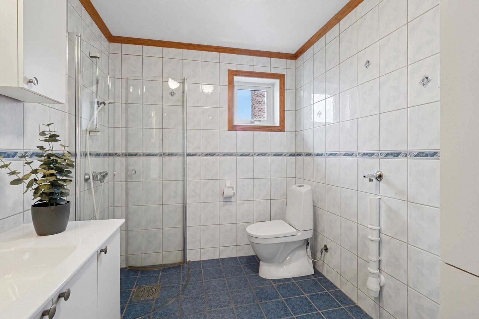 Helfliset bad med elektriske varmekabler i gulvet. Dusj med innfellbare glassdører. Galleribilde