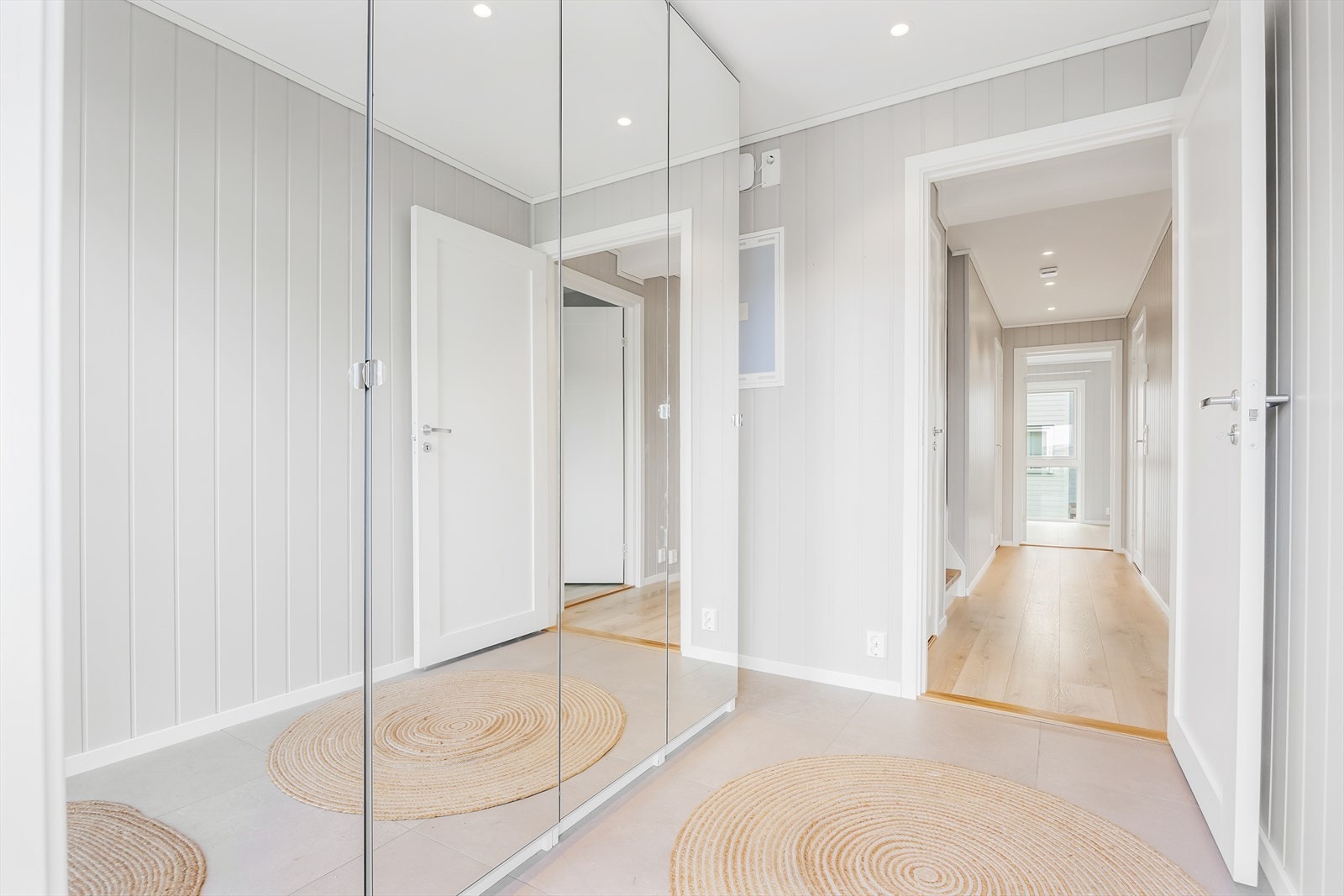 Entre med flislagt gulv og tilhørende garderobeskap. Galleribilde