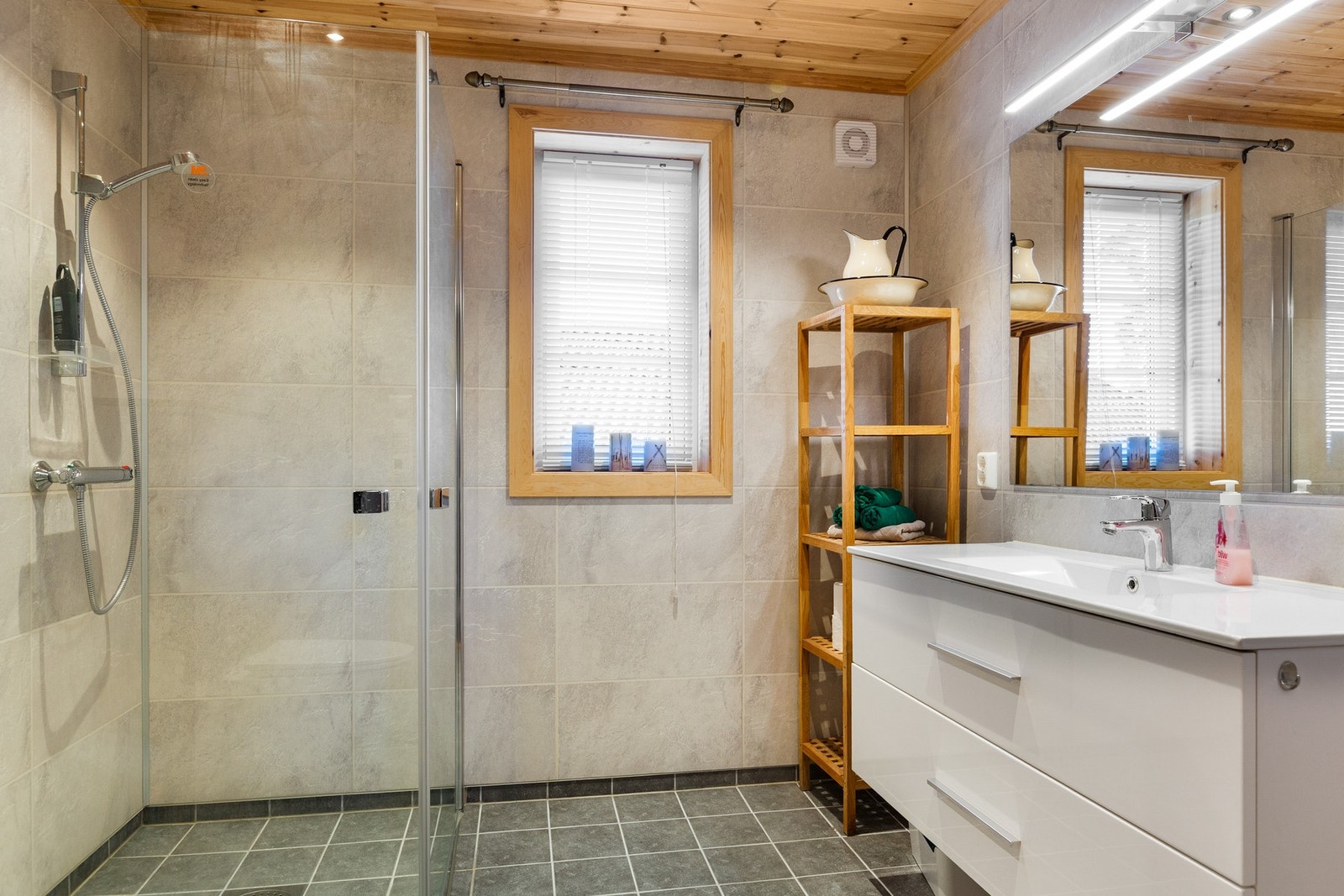 Moderne innredning med servant, dusjvegger i glass og vegghengt toalett. Galleribilde