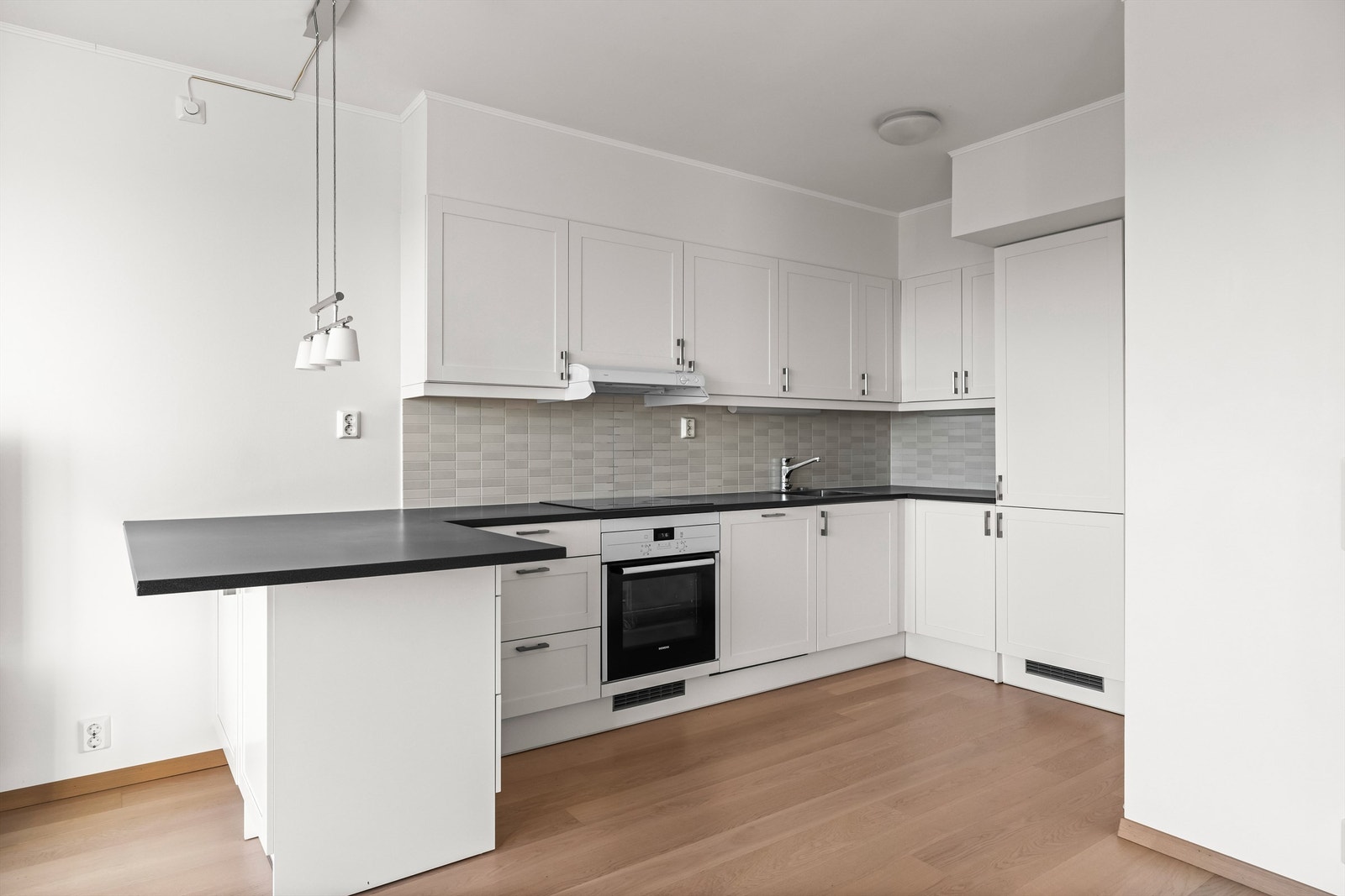 Kjøkkenet har slette fronter, benkeplate i slitesterk laminat og praktiske fliser mellom benkeplate og overskap. Galleribilde