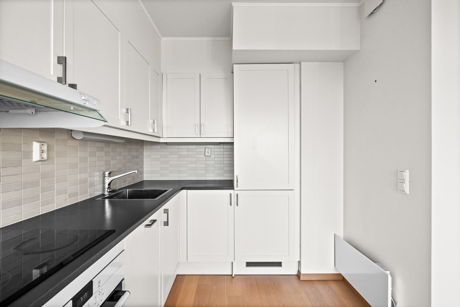 Kjøkkenet har integrerte hvitevarer som kjøleskap med frysedel, oppvaskmaskin og komfyr med induksjonstopp. Galleribilde