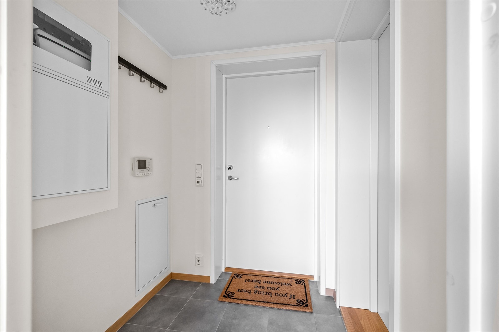 Lys og praktisk entré med flislagt gulv med varme. Galleribilde