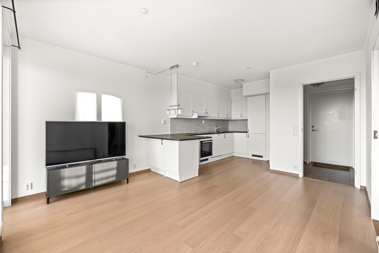 Stuen har en åpen og sosial løsning mot kjøkkenet. Galleribilde