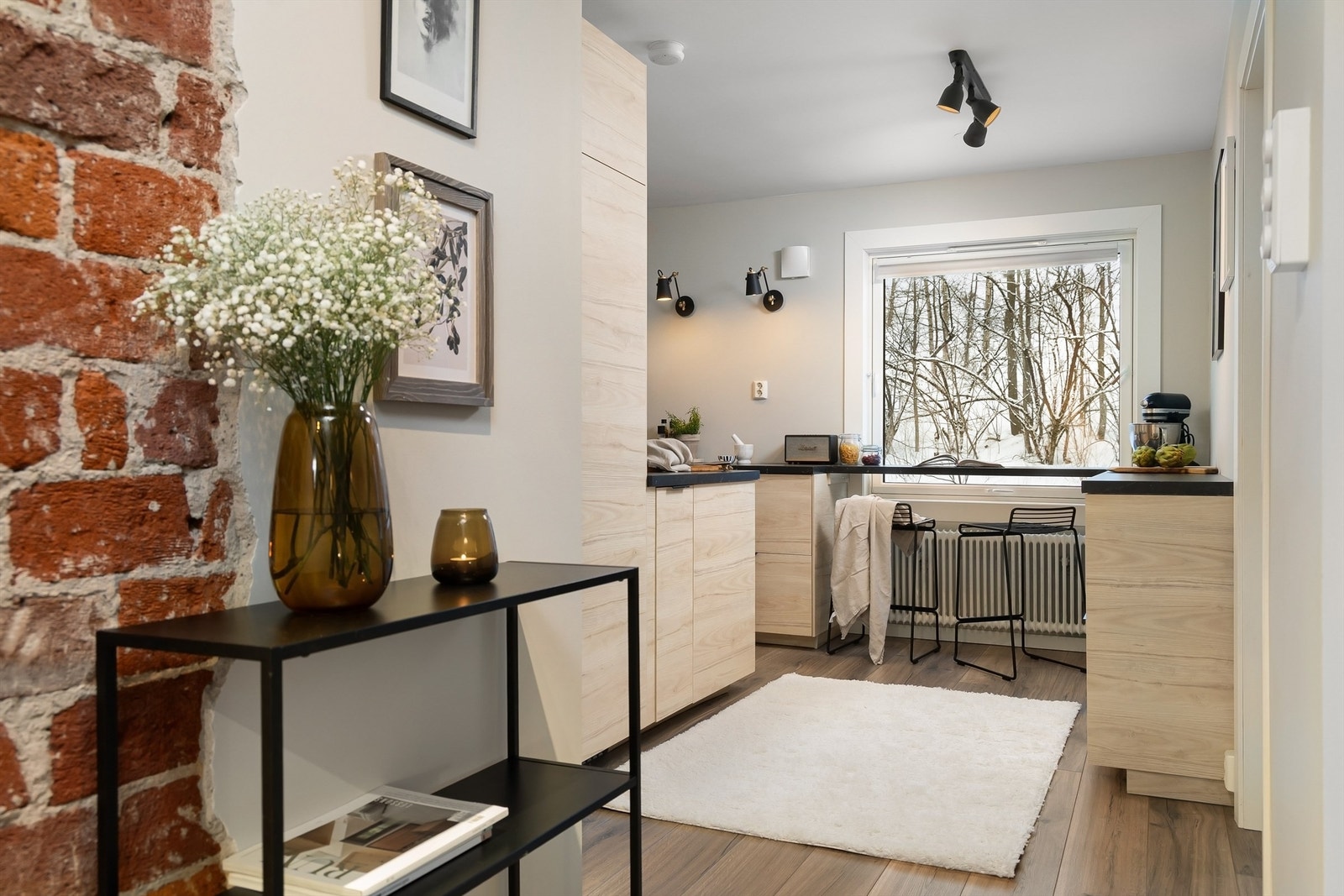 Pent og innholdsrikt kjøkken delvis skjermet fra stuen Galleribilde