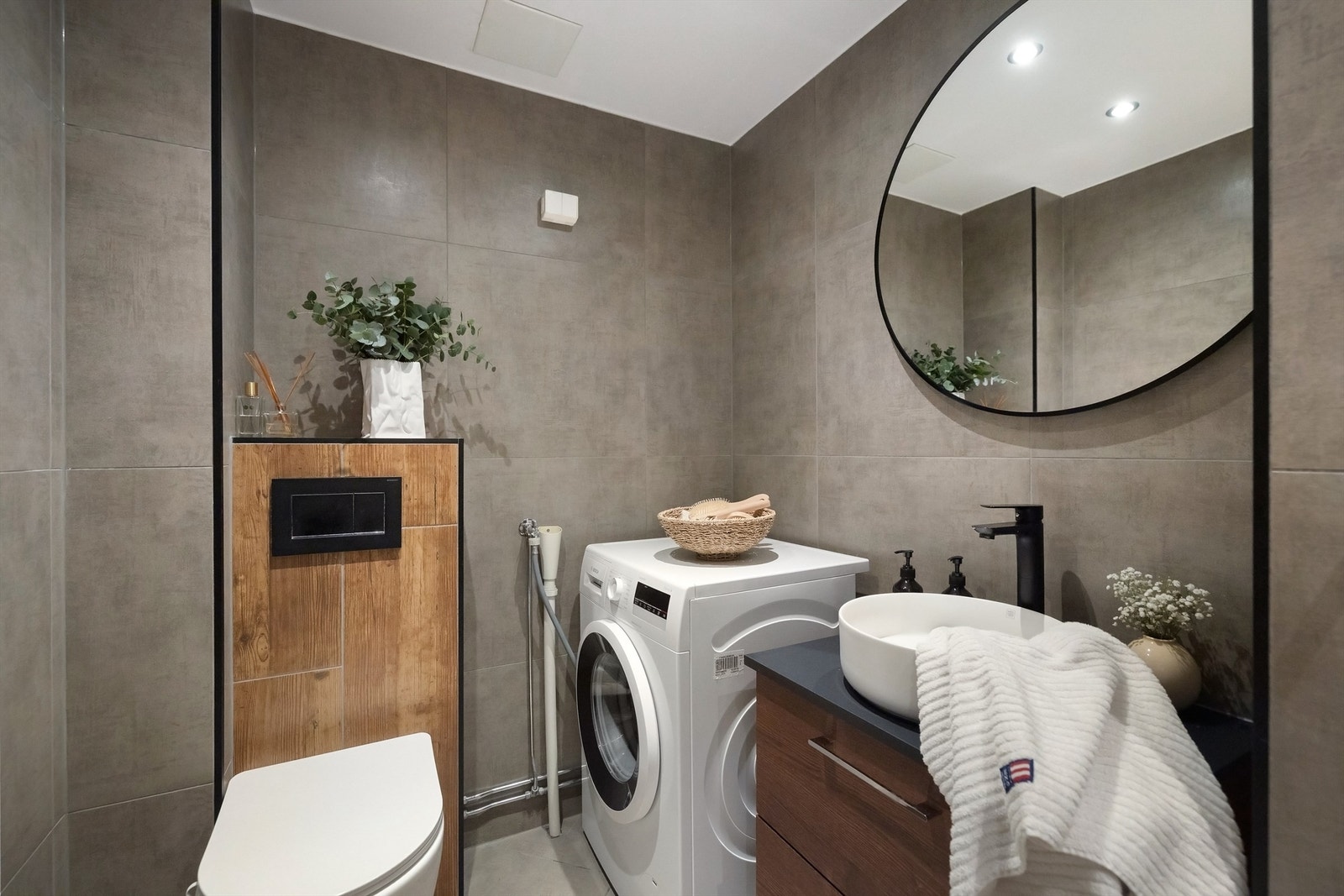 Videre er badet innredet med heldekkende servantskap med skuffeinnredning, ovenpåliggende servant og speil over Galleribilde