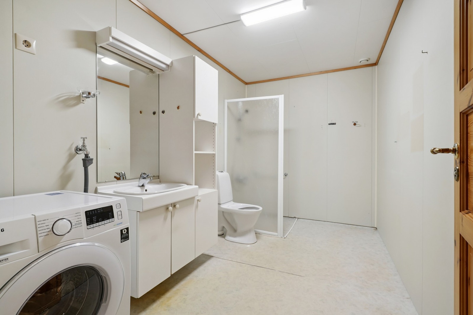 Romslig bad/vaskerom med våtromsbelegg på gulv og malte plater på vegger. Elektriske varmekabler i gulvet. Galleribilde