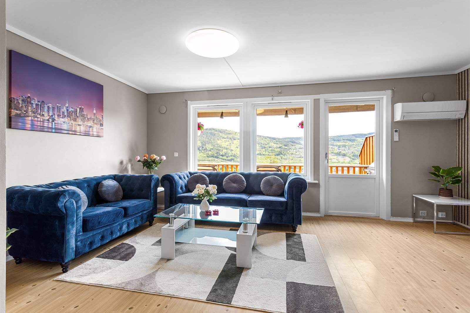 Lekker stue med parkett på gulv og slette vegger malt i et pent fargepallett. Galleribilde