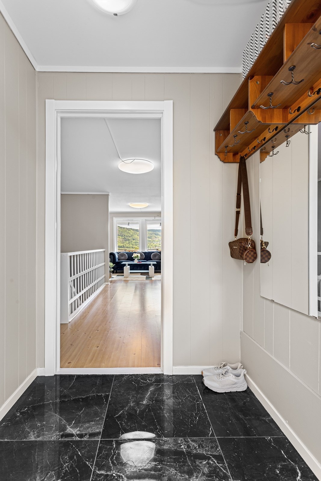 Velkommen inn til en flislagt entrè, der det er rom for oppheng av yttertøy og til å sette ifra seg sko. Galleribilde