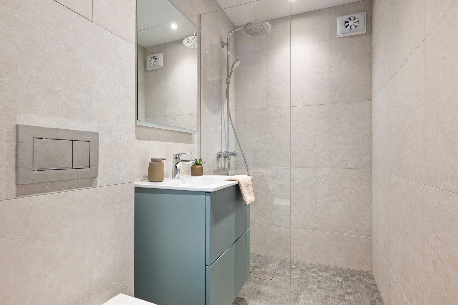 Stilrent baderom fra 2019 med fliser, gulvvarme, dusjhjørne med regnfallsdusj og moderne innredning. Galleribilde