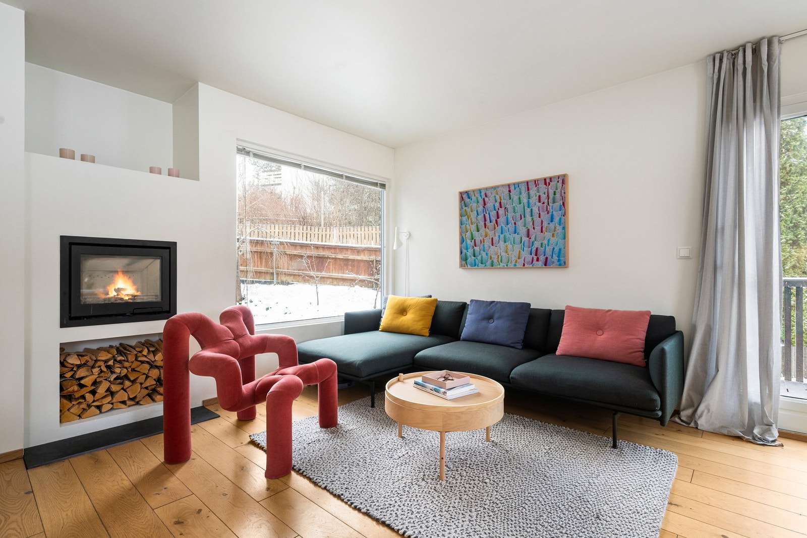 Koselig sofasone med stilren Contura peisinnsats fra 2014 som gir både god varme og stemning, samt praktisk nisje for vedoppbevaring. Galleribilde