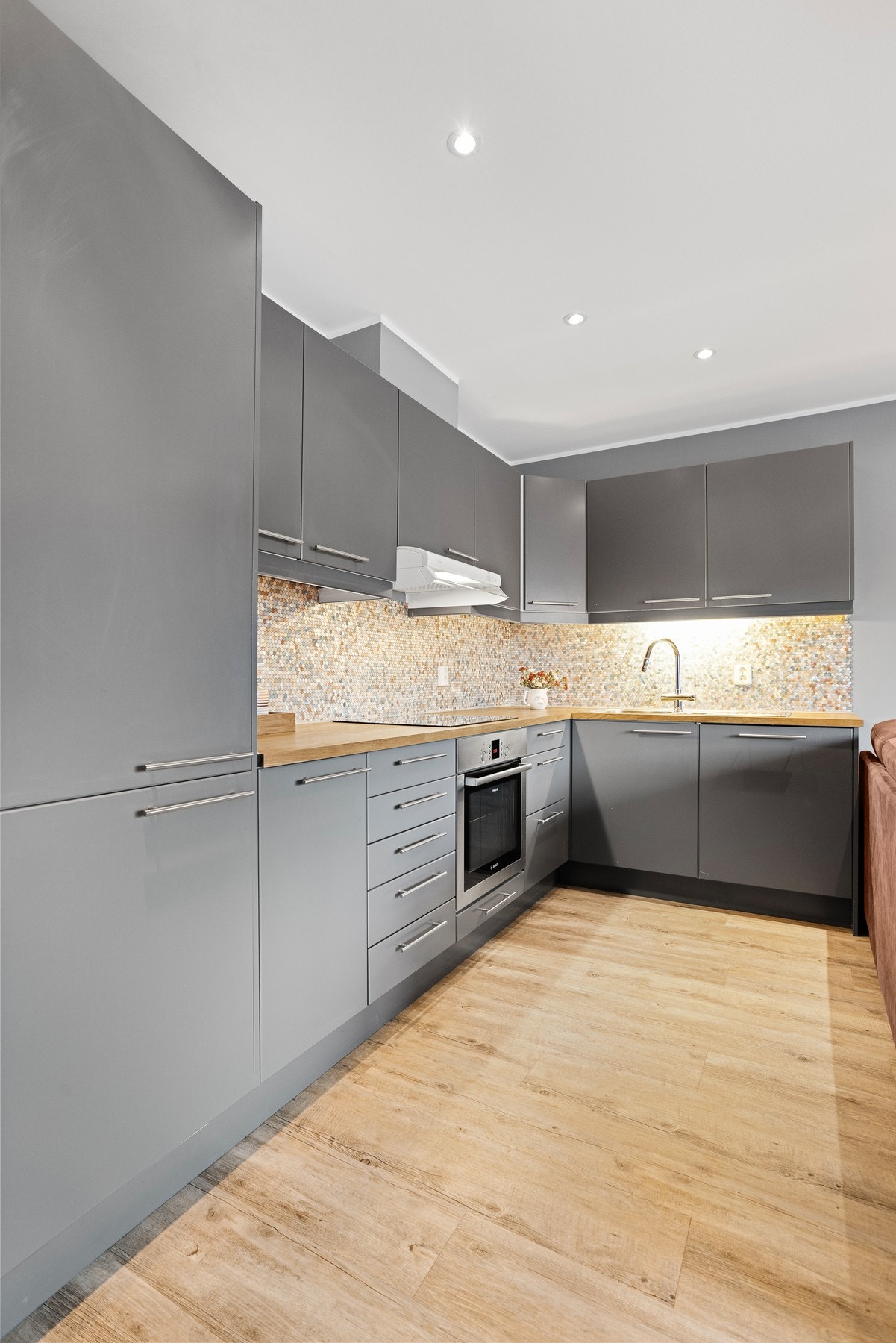 Kjøkkenet med integrerte hvitevarer som platetopp, ovn, oppvaskmaskin og kjøl/fryseskap Galleribilde