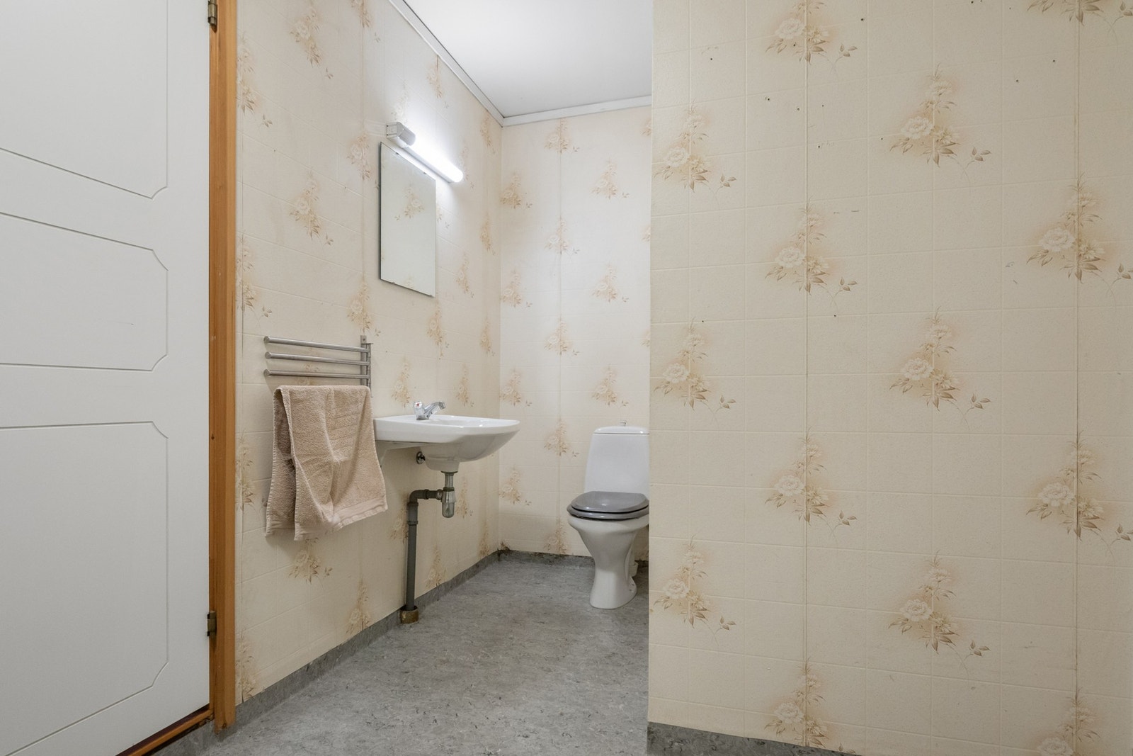 Badet er innredet med gulvbelegg og våtromstapet. Galleribilde