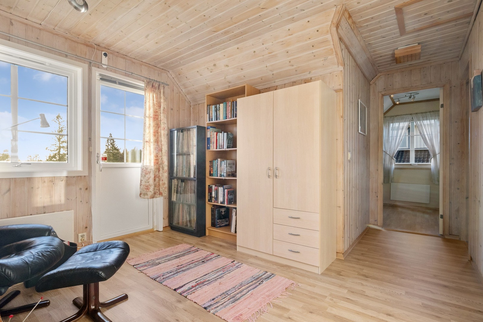 Veggene er kledd med trepanel, og stuen forlenges av en trivelig balkong med fin utsikt. Galleribilde