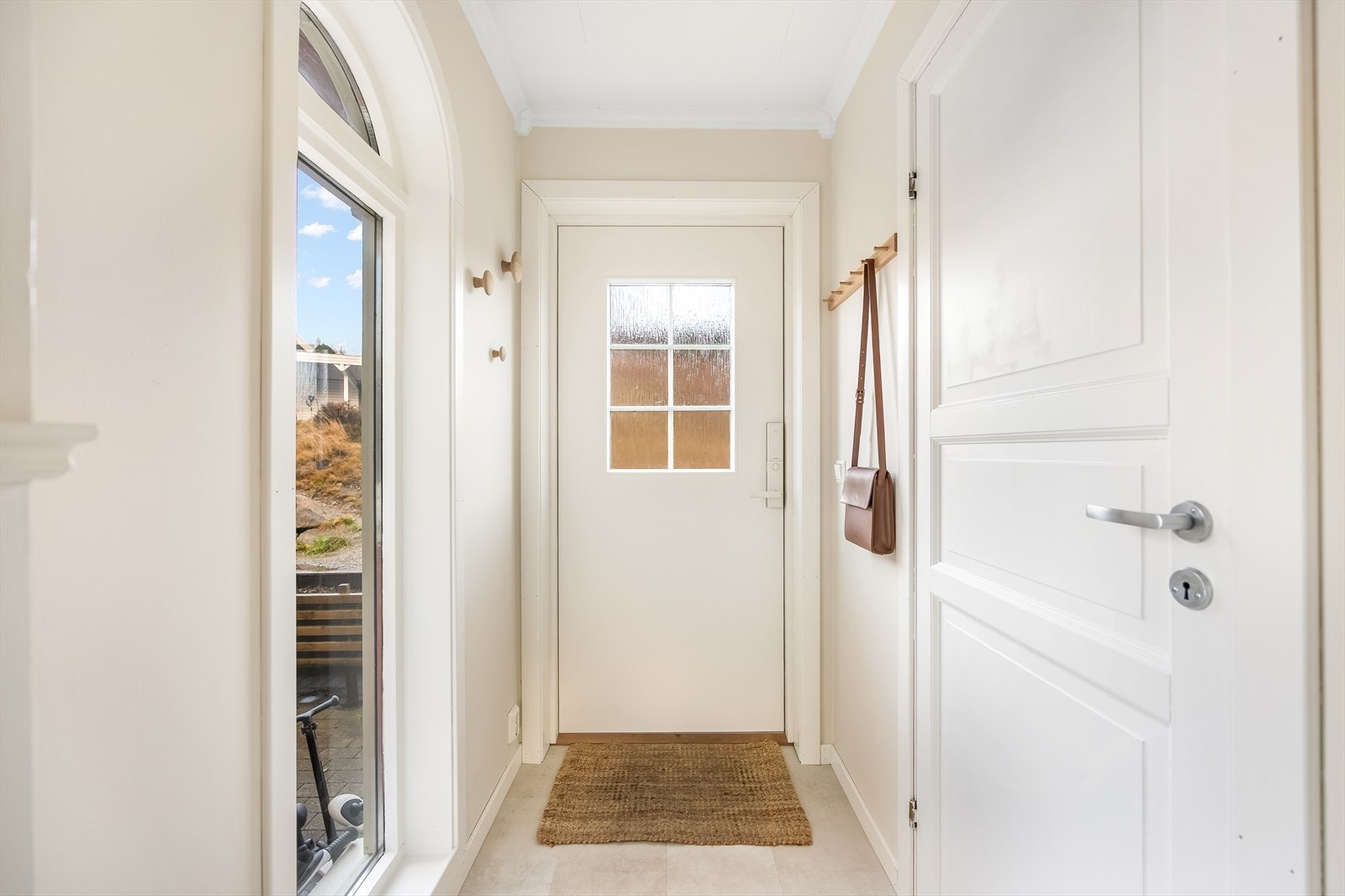 Entre/gang med adkomst til gjestetoalett. Stort vindu slipper fint naturlig lys inn. Galleribilde