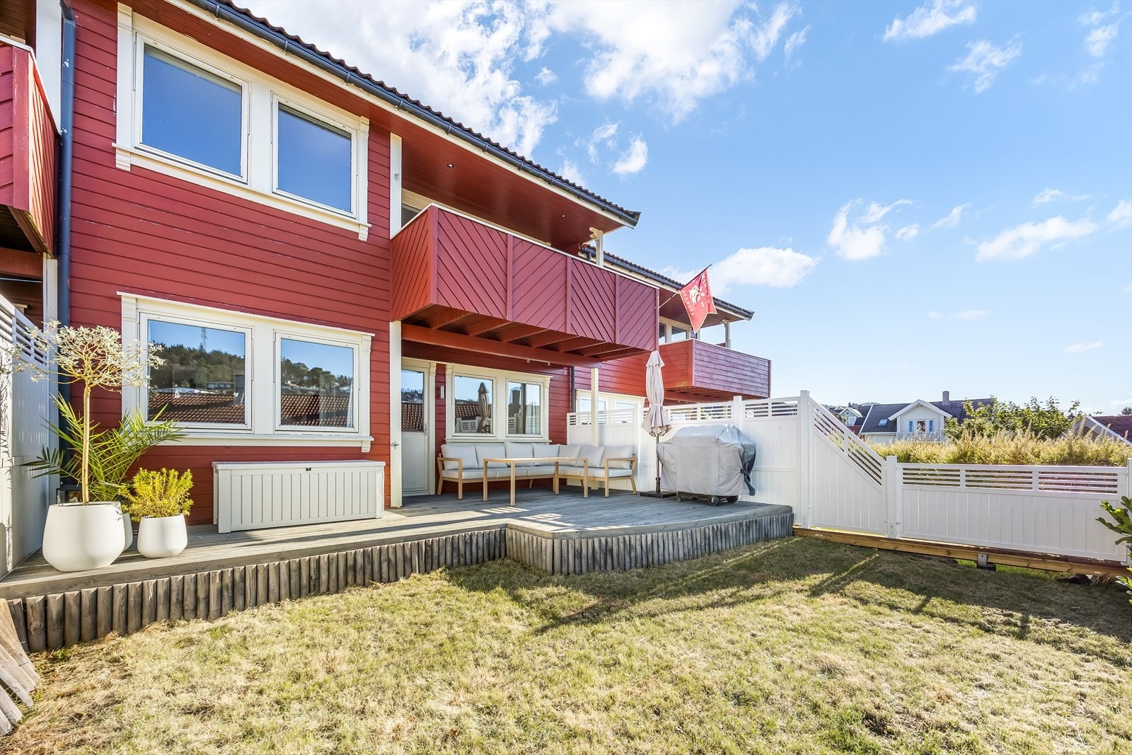 Pent opparbeidet tomt med terrasse og plen. Galleribilde