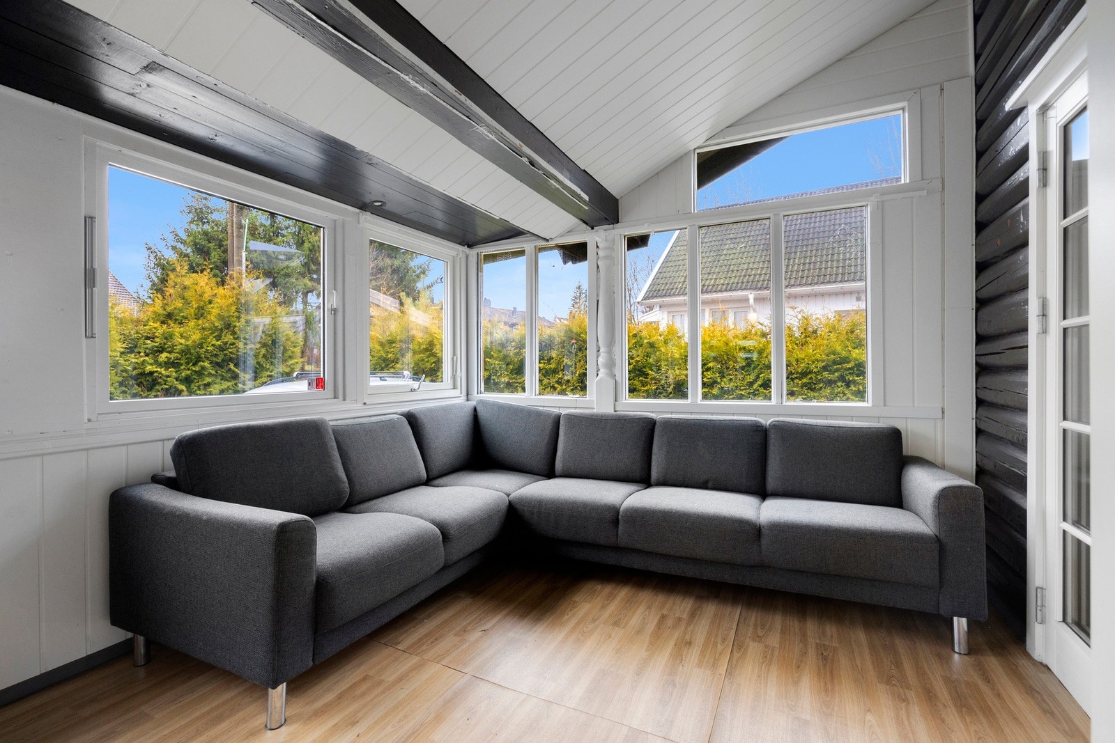 Fra stuen kommer man ut til en innglasset terrasse som blir en naturlig forlengelse av stuen Galleribilde