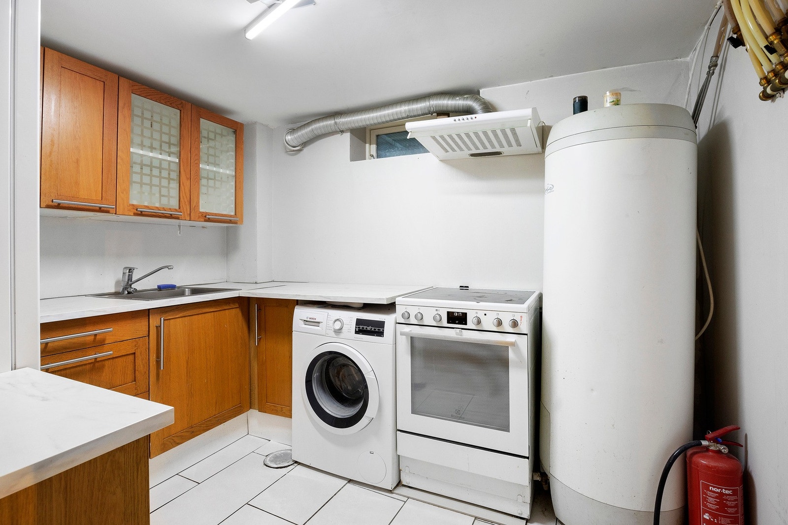 Rom innredet som kjøkken med profilerte fronter og laminat benkeplate. Frittstående komfyr og opplegg for vaskemaskin. Ikke godkjent for varig opphold Galleribilde