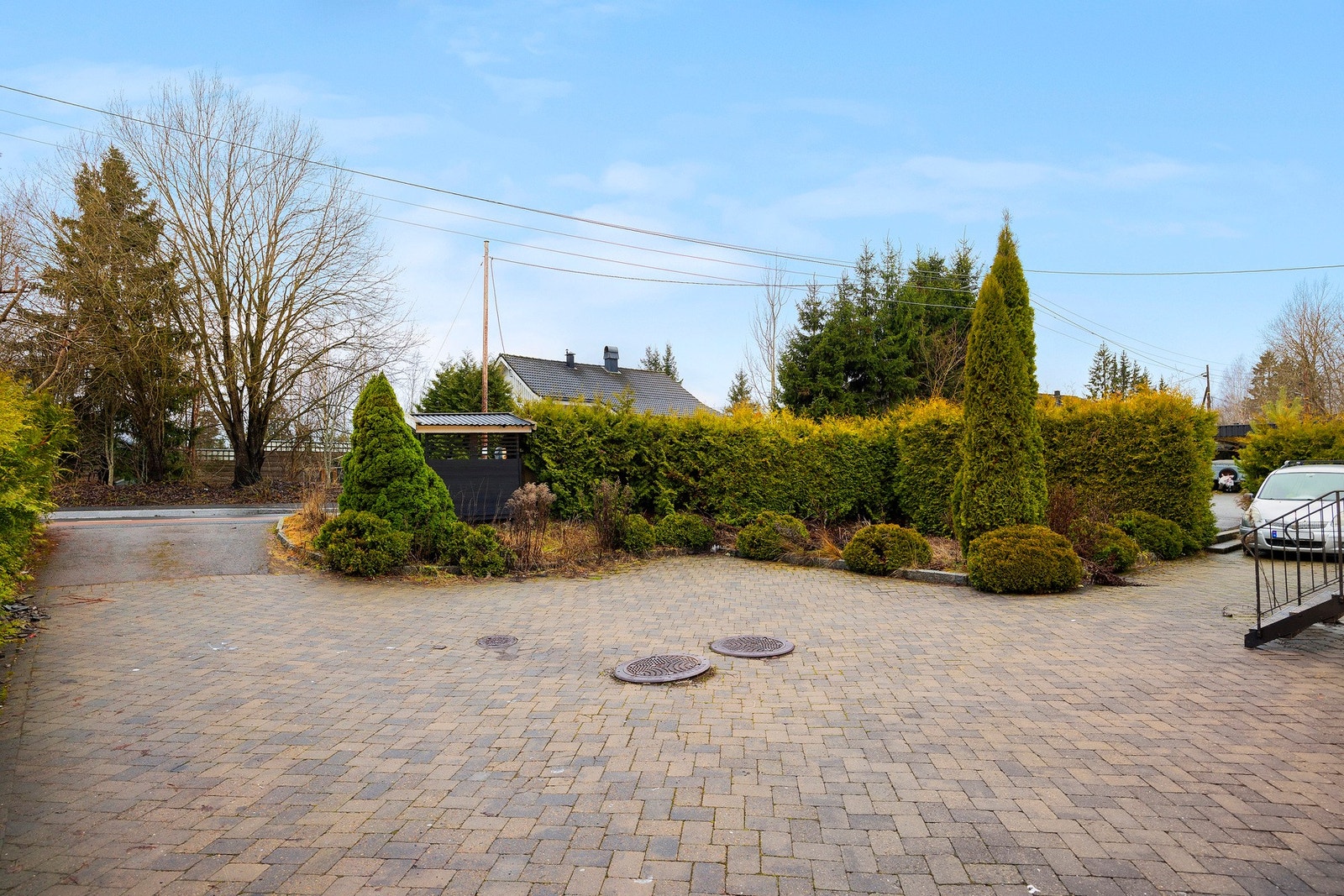 Det er godt med plass til biler i gårdstunet. I tillegg er det garasje med montert elbil-lader Galleribilde