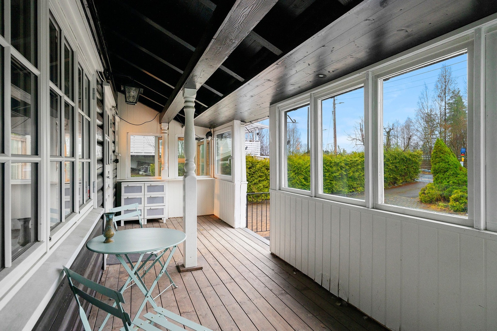 Videre kommer man til overbygd terrasse foran inngangsdøra. Her er det ikke helt lukket, men man sitter fortsatt i ly for vær og vind Galleribilde