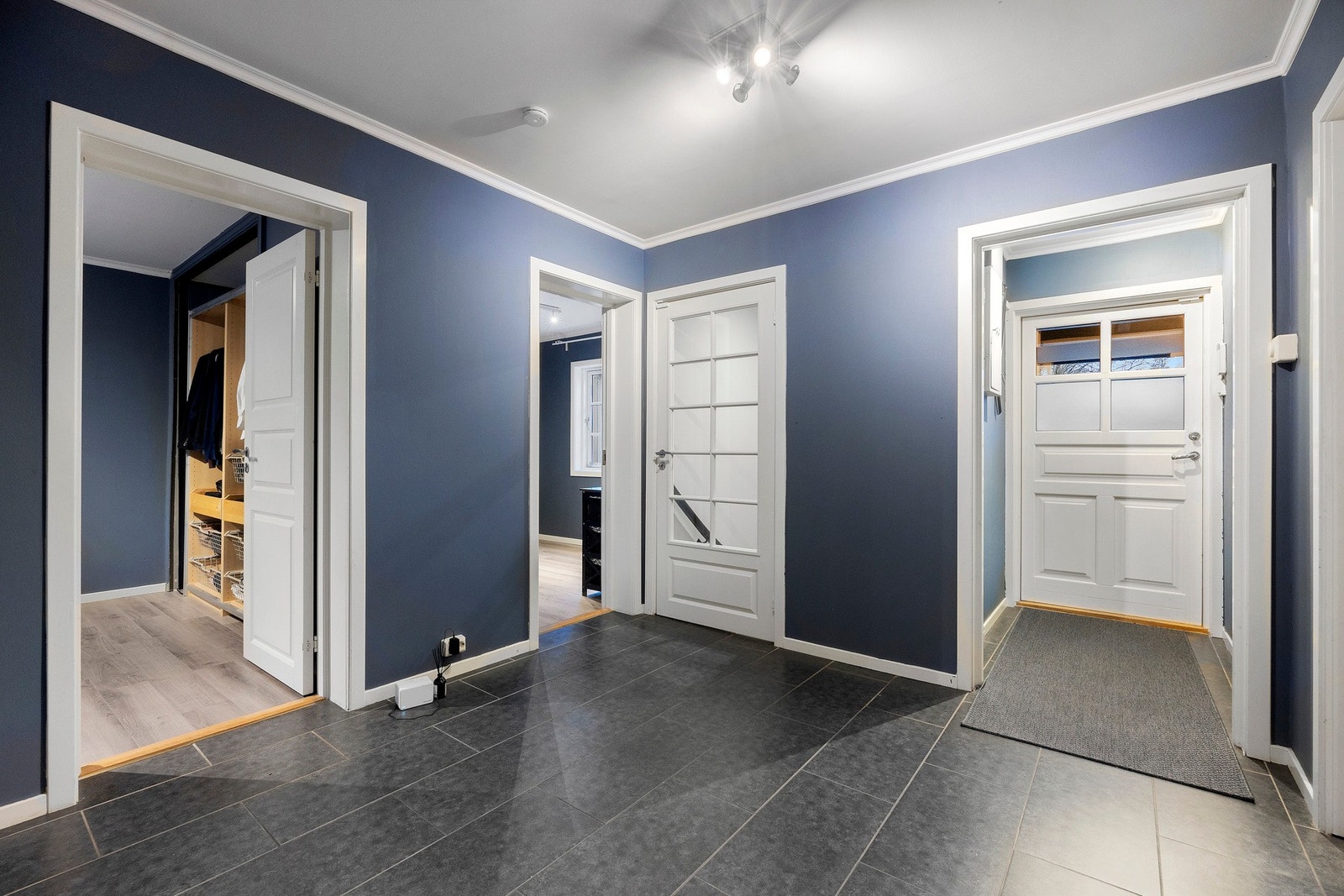 Romslig gang i tilknytning til inngangspartiet. Herfra kommer du til boligens to soverom, det ene badet og spisestuen, samt trapp ned til kjelleren Galleribilde