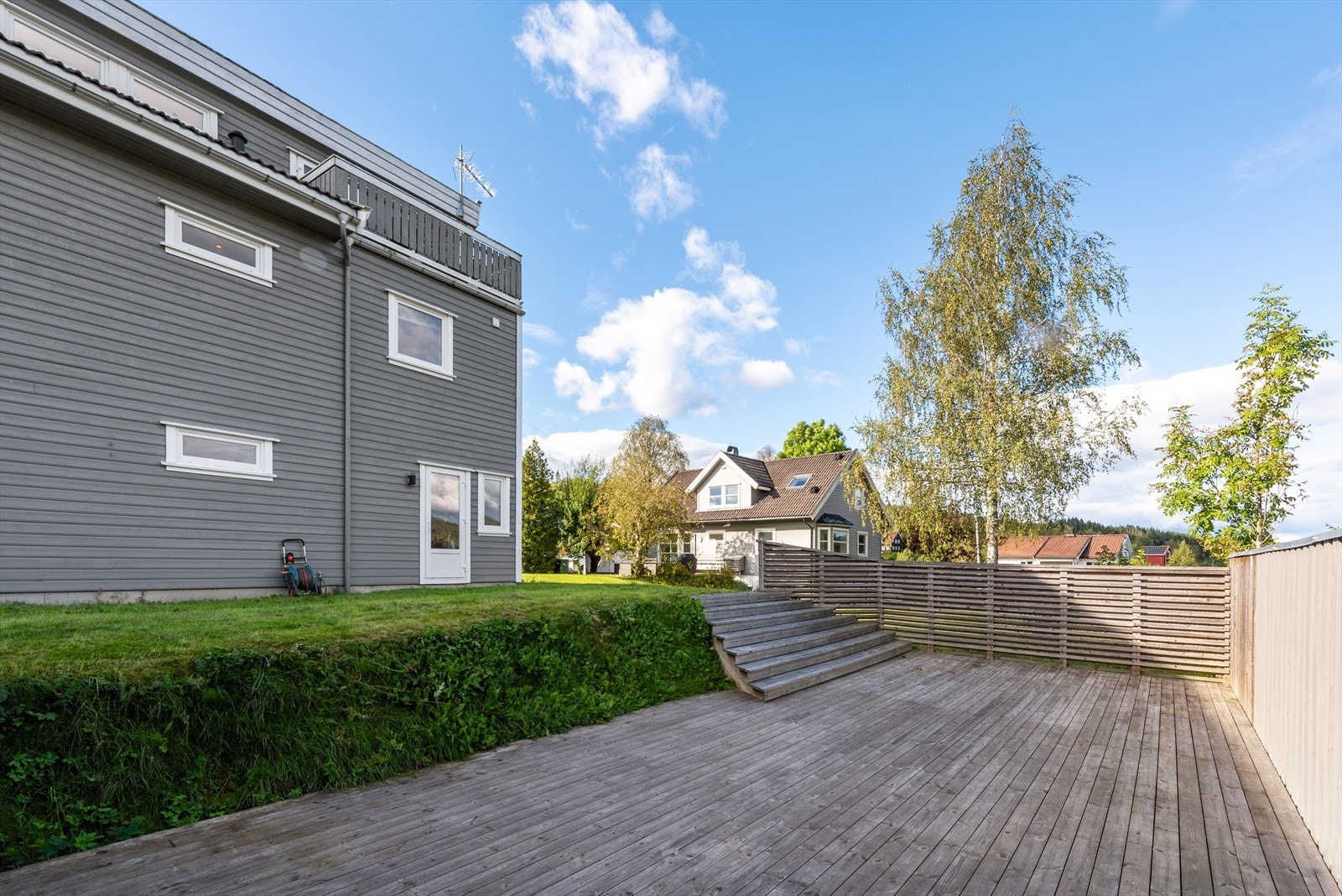 Lettstelt tomt som er delvis innegjerdet, opparbeidet med plenarealer, hekk, tre, samt stor uteplass på baksiden av boligen. Galleribilde