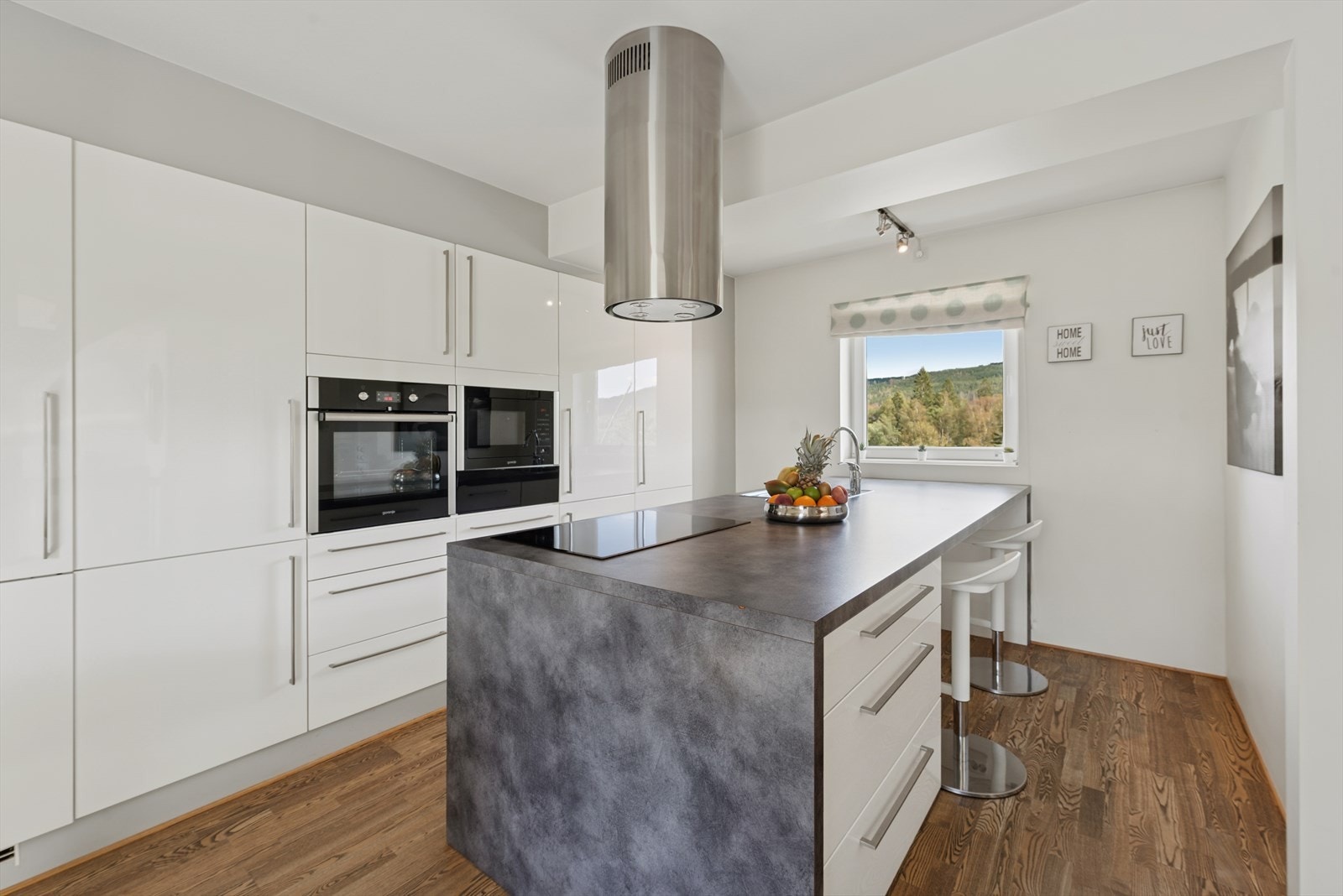 Kjøkkeninnredningen har slette, hvite fronter og laminat benkeplate for et stilrent uttrykk. Galleribilde