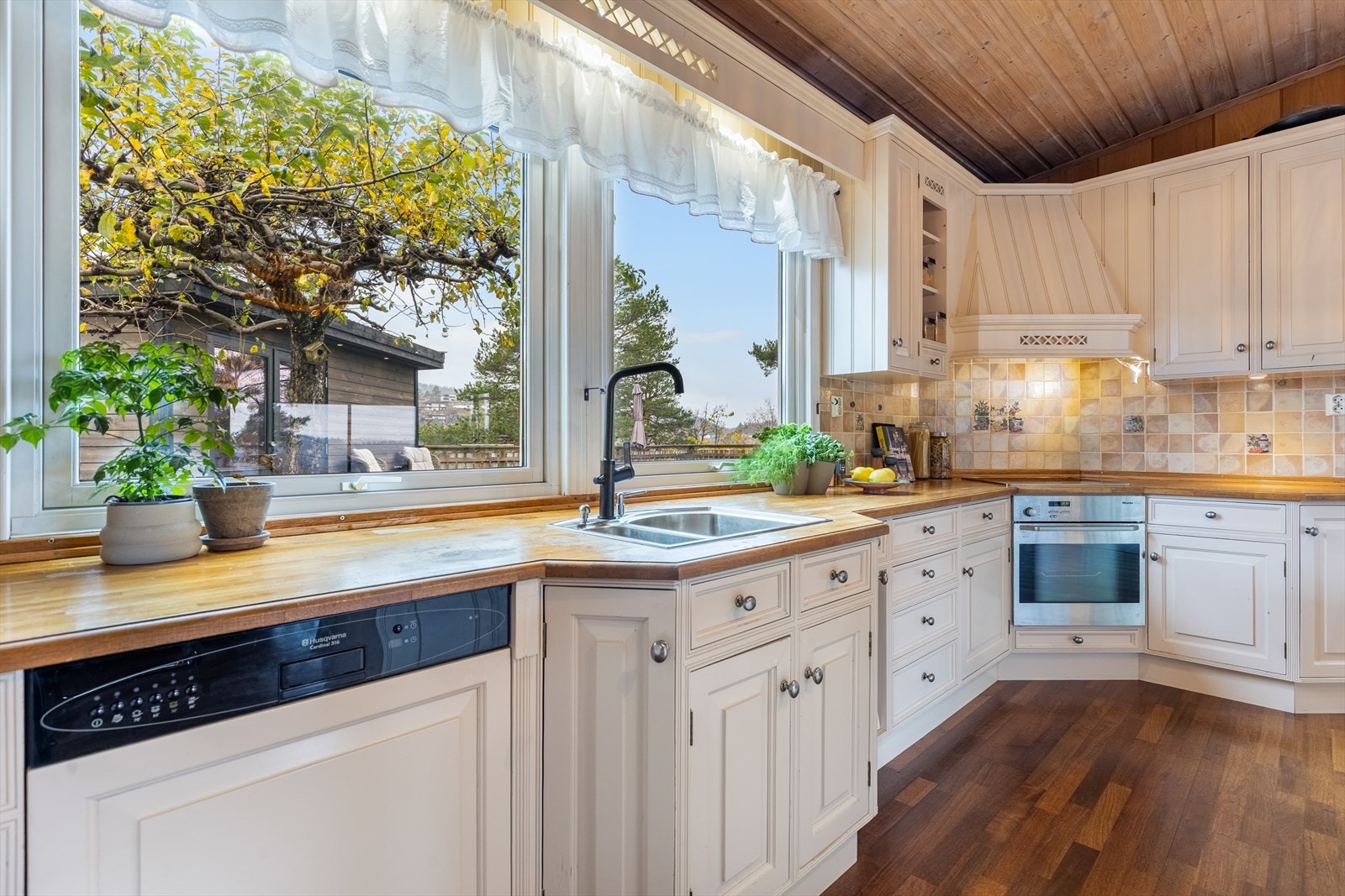 Lys og fin kjøkkeninnredning med integrerte hvitevarer Galleribilde