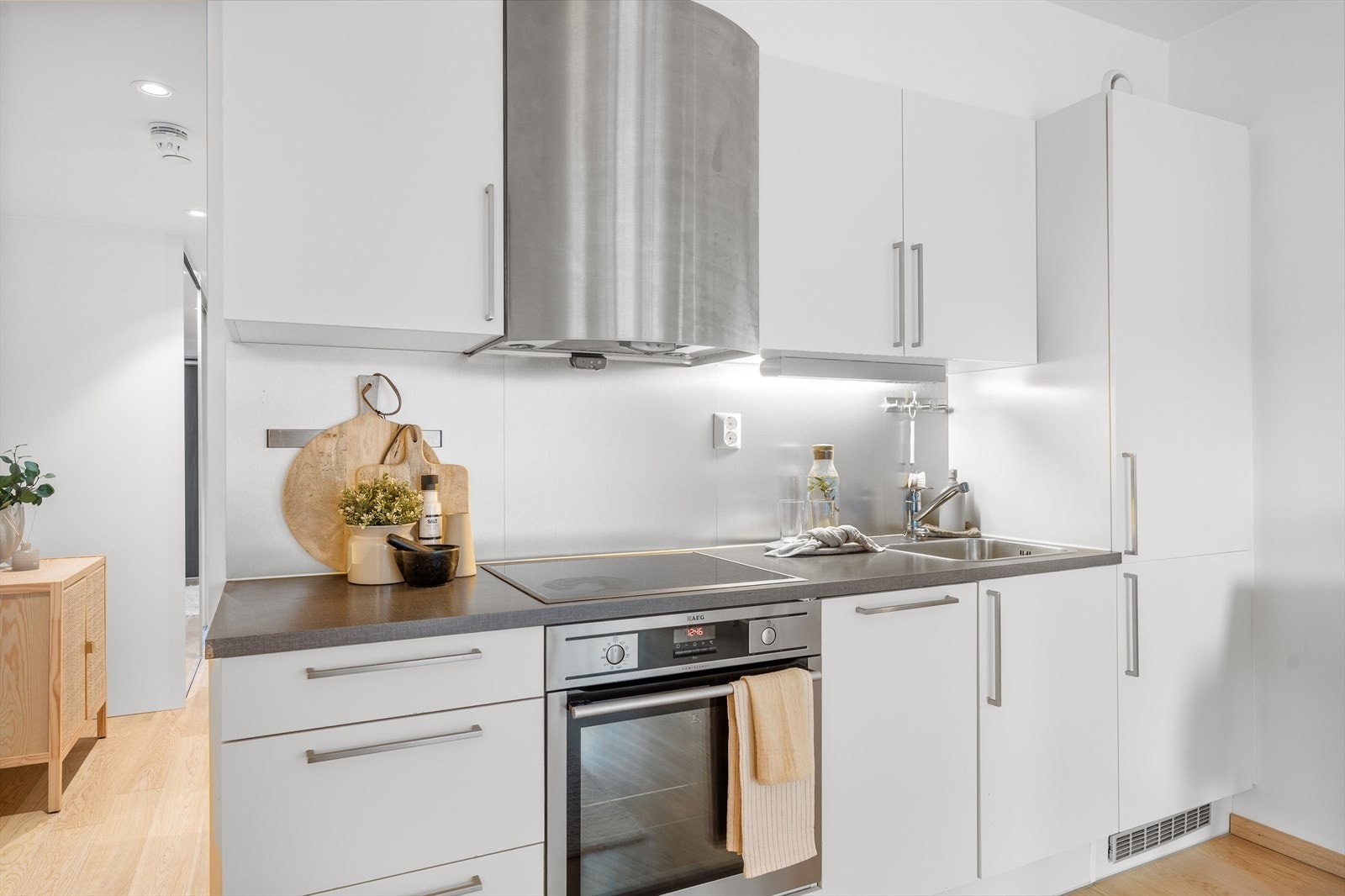 Kjøkkenet er innredet med mekanisk avtrekksvifte over stekesonen og opplegg for oppvaskmaskin. Det er integrert platetopp, stekeovn, kjøleskap, fryser og oppvaskmaskin. Videre er det lekkasjedetektor med vannstoppventil og komfyrvakt over stekesonen. Galleribilde