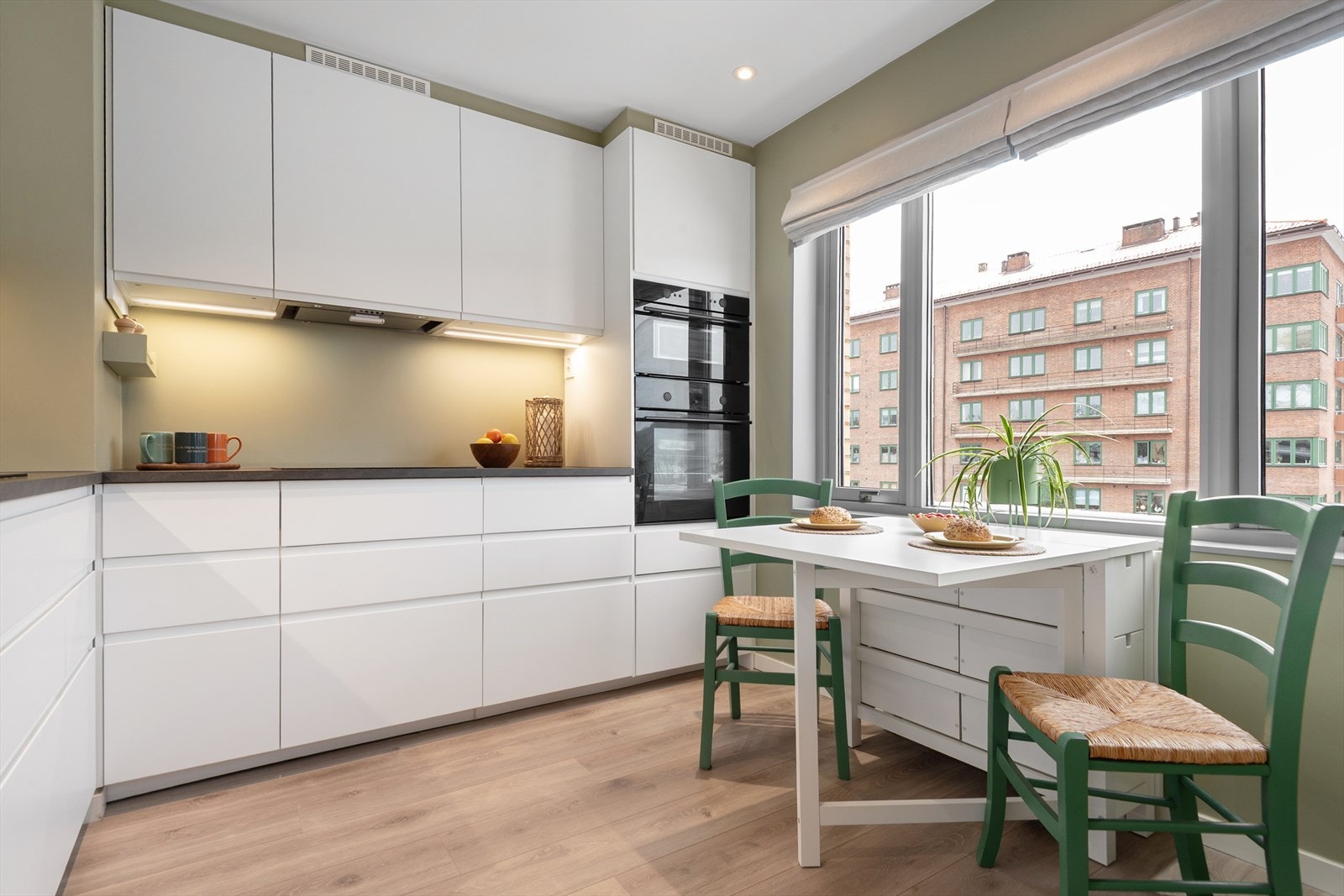 Kjøkkenet ligger separat og har plass til et hyggelig spisebord ved vindu Galleribilde