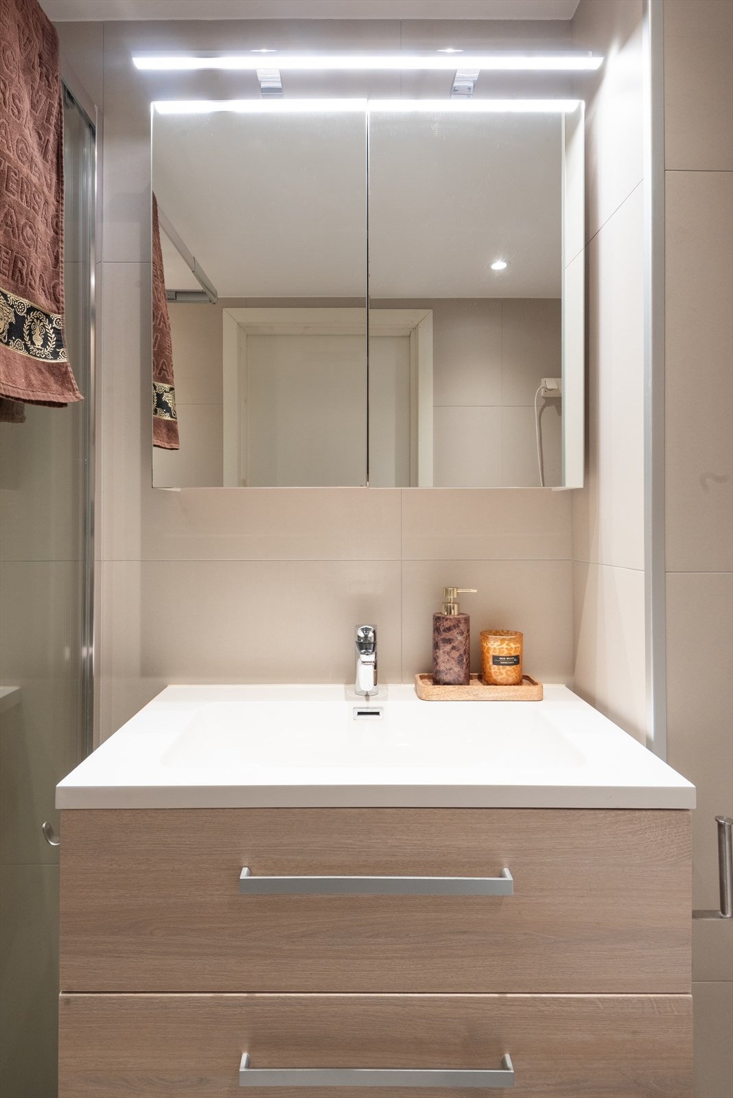 Badet ble oppgradert med flis på flis i 2018 og har flislagte overflater, dusj med fast felt i herdet glass, vegghengt toalett med innebygget sisterne og servant med benkeskap Galleribilde