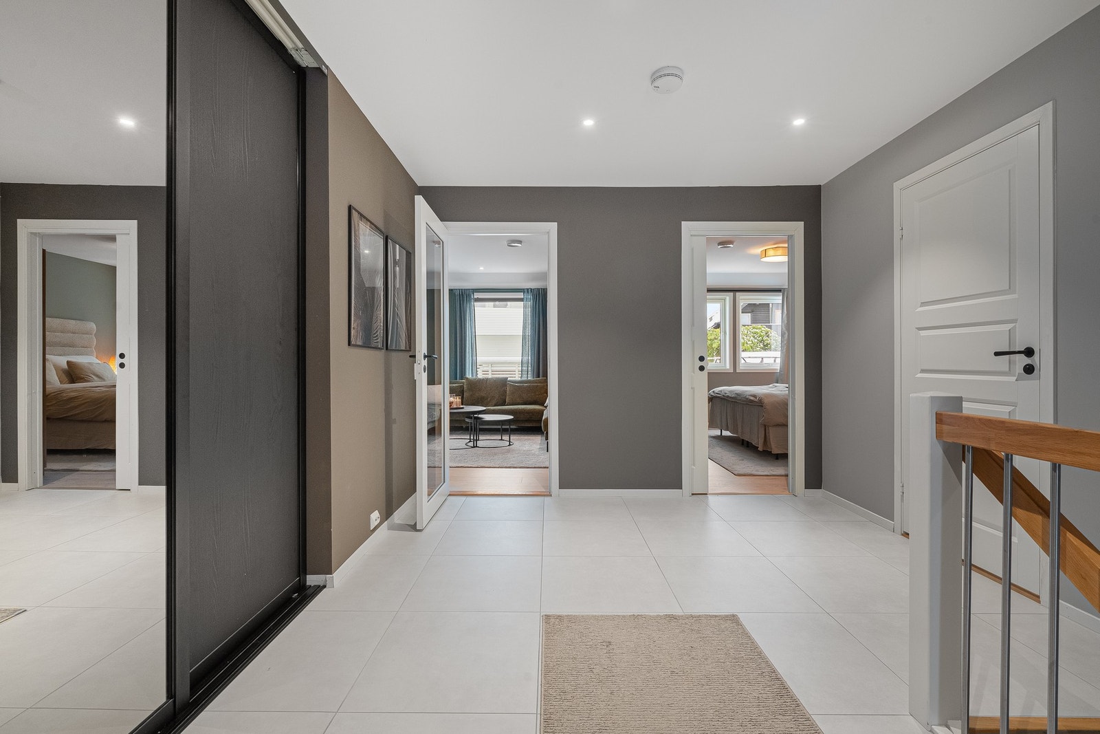 Romslig gang med fliser på gulv og skyvedørsgarderobe. Galleribilde