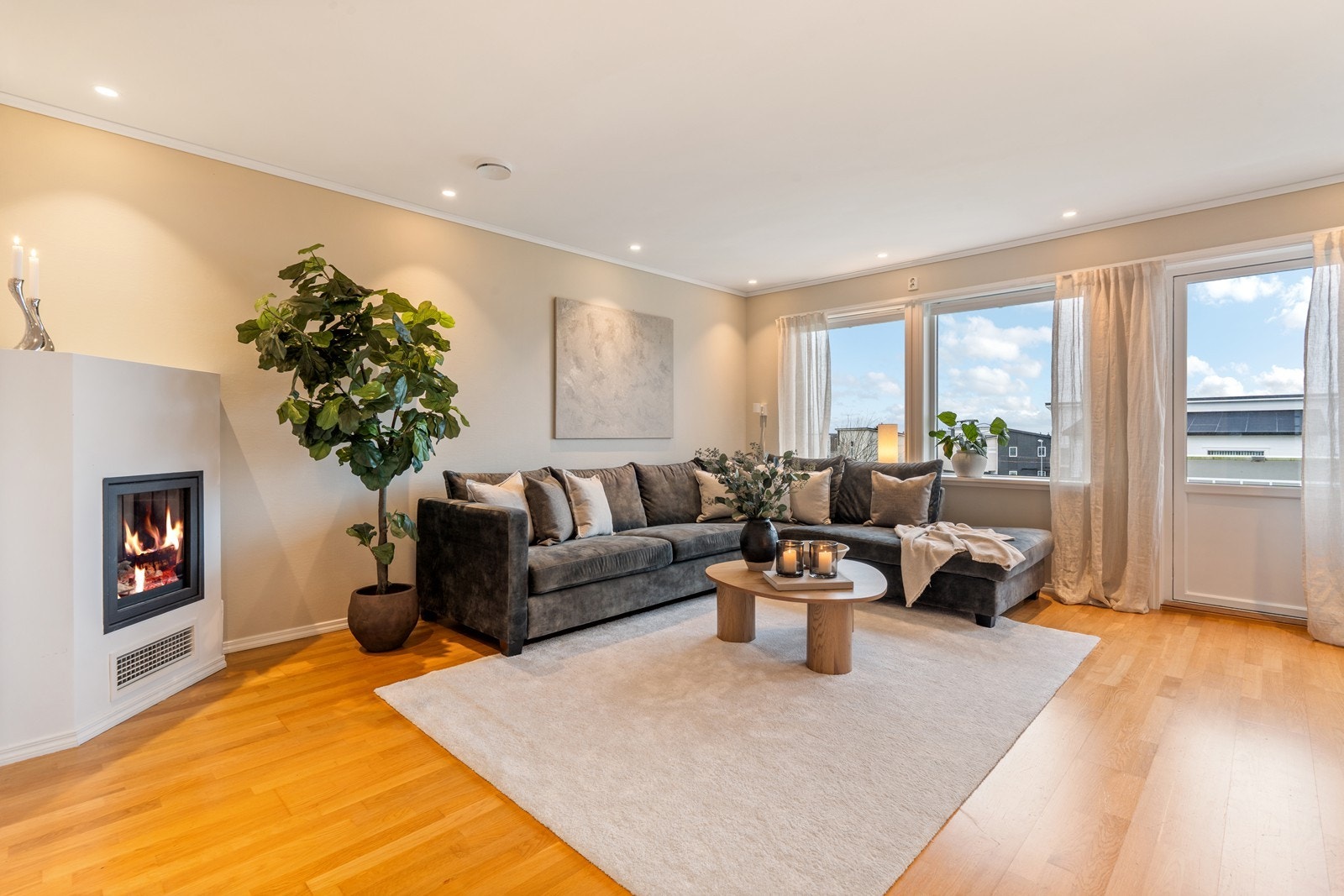 Lys og innbydende stue med gasspeis og dør til balkong Galleribilde