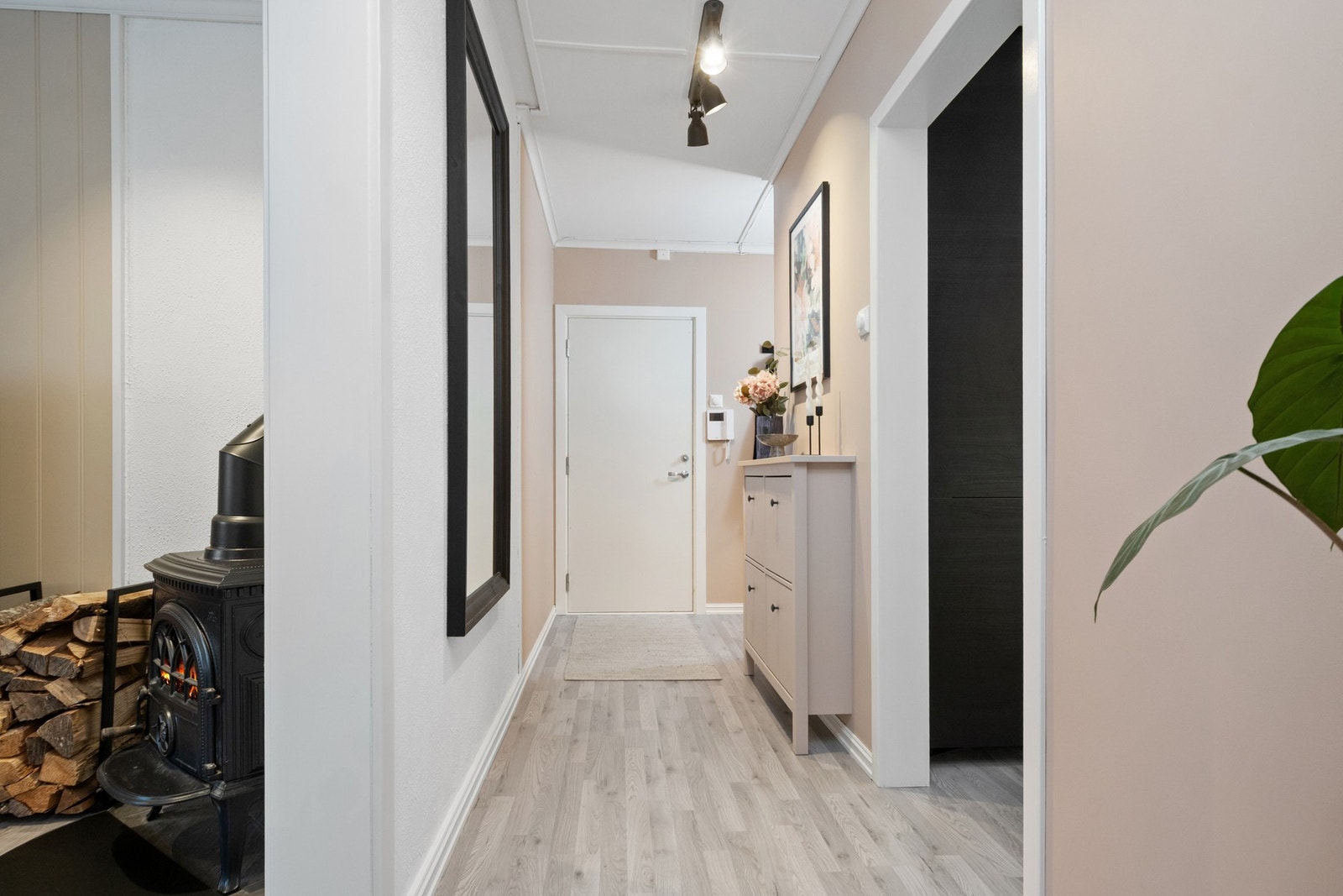 Vel inne har gangen dørtelefon, laminatgulv og vegger malt i en dus beigetone. Galleribilde