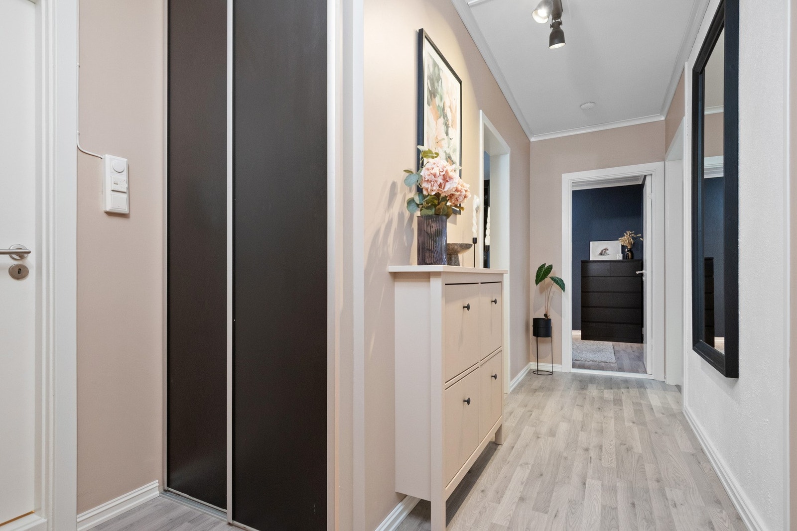 Plassen er godt utnyttet, og i gangen finner man en plassbygd skyvedørsgarderobe med sorte fronter. Galleribilde