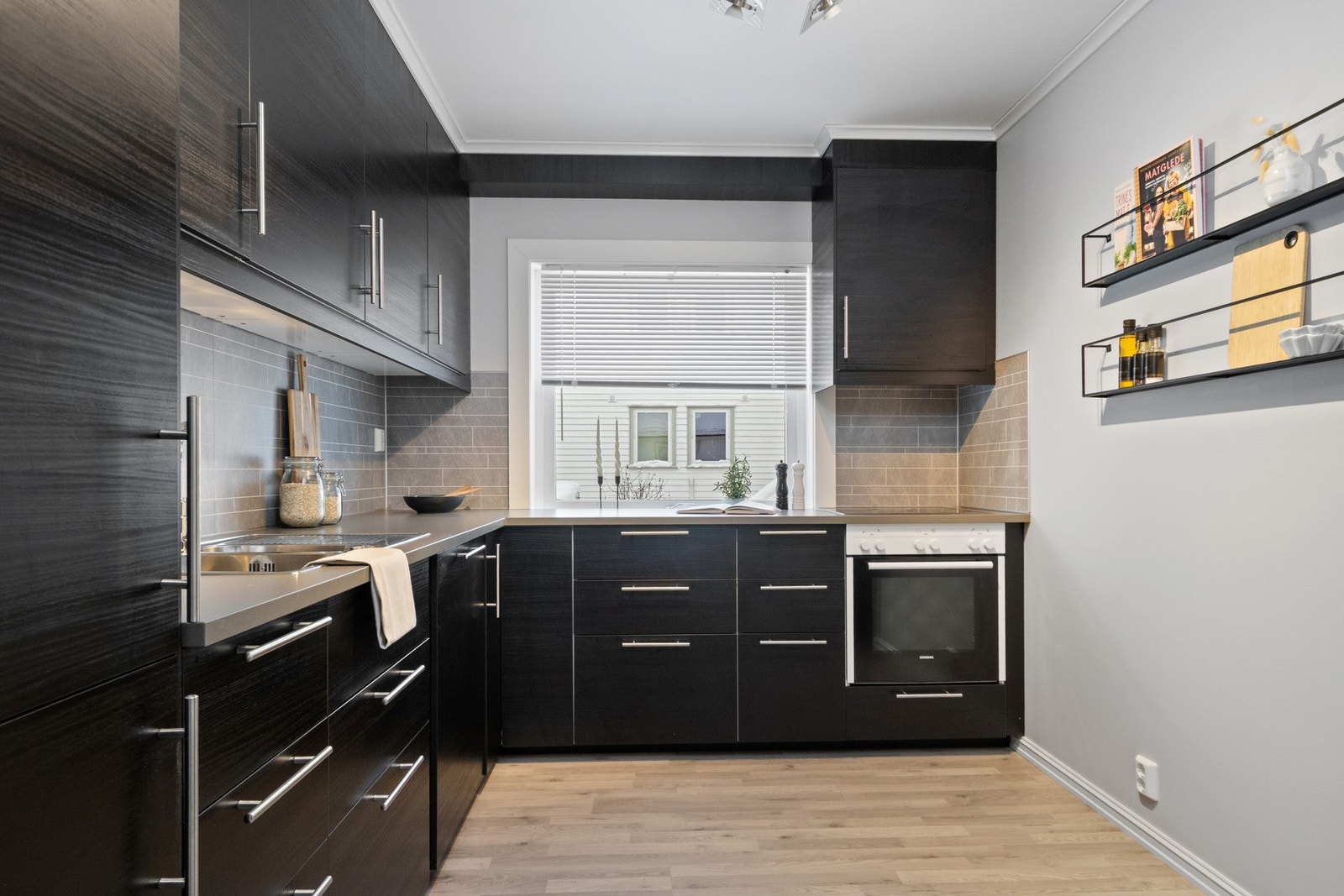 Innredningen ble montert i 2018, med sorte, glatte fronter, dobbel oppvaskkum og laminerte benkeplater. Galleribilde