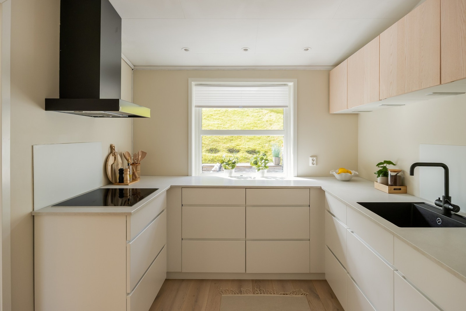 Velutstyrt med integrert induksjonstopp, oppvaskmaskin, komfyr i arbeidshøyde, kjøleskap og mekanisk avtrekksvifte. Galleribilde