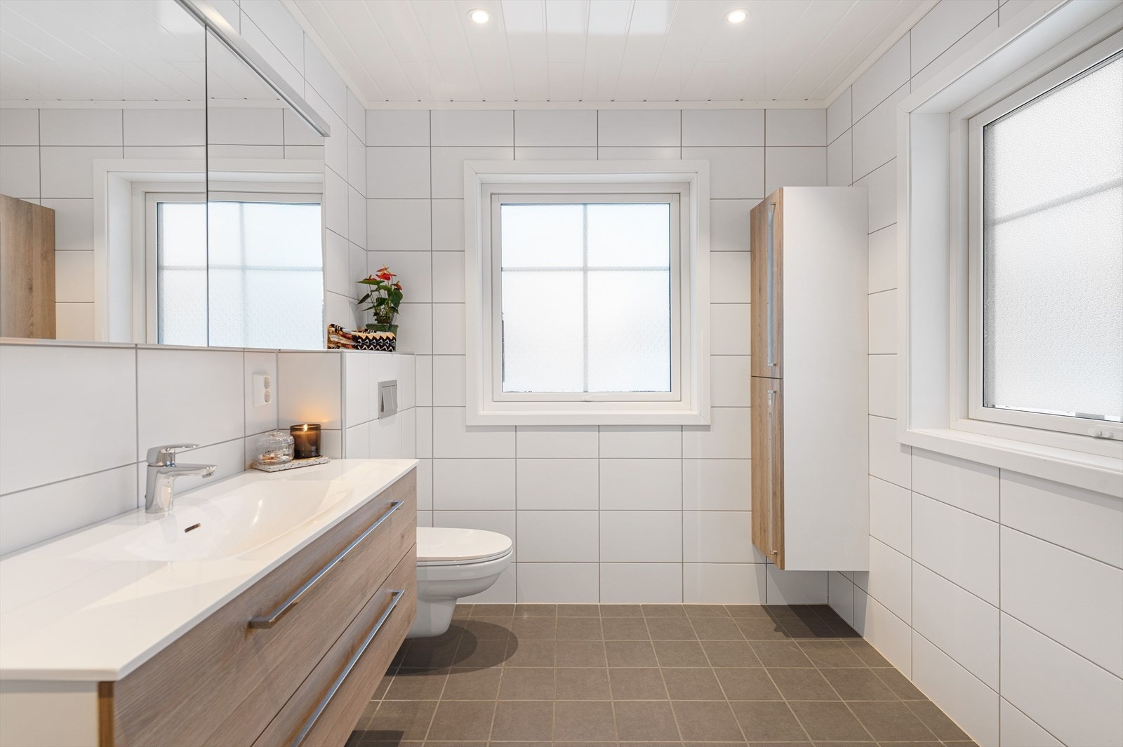 Pent helfliset bad i 2.etasje med downlights i himling. God oppbevaringsplass i innredning. Frostede ruter for null innsyn. Galleribilde