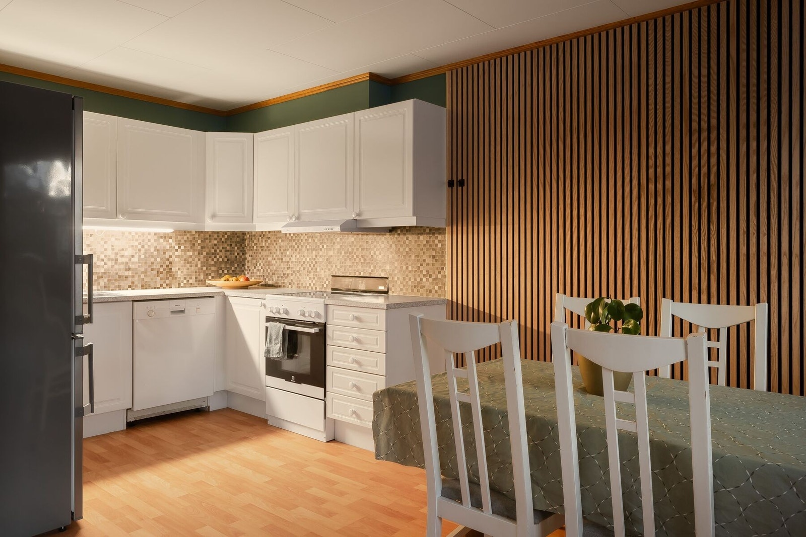 Klassisk hvitt kjøkken med over- og underskap, og frittstående hvitevarer. Galleribilde