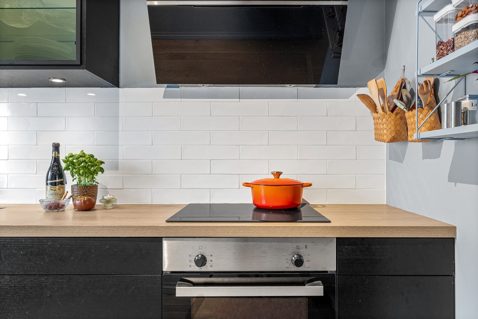 Videre er det montert kjøkkenventilator med avtrekk ut og vegg over benkeplate er flissatt Galleribilde