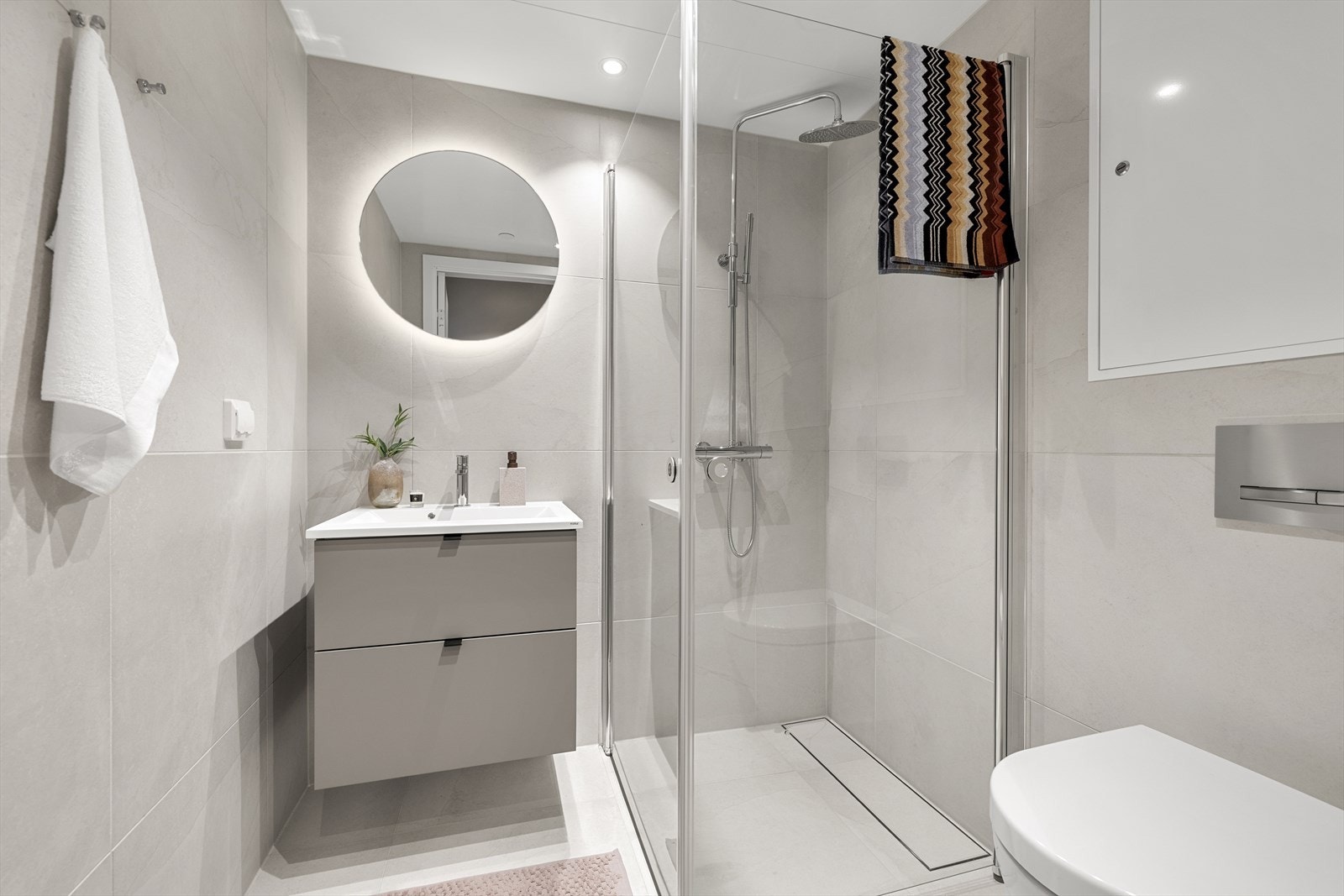 Badet tilknyttet hovedsoverommet har vegghengt toalett og et speil med integrert belysning. Galleribilde