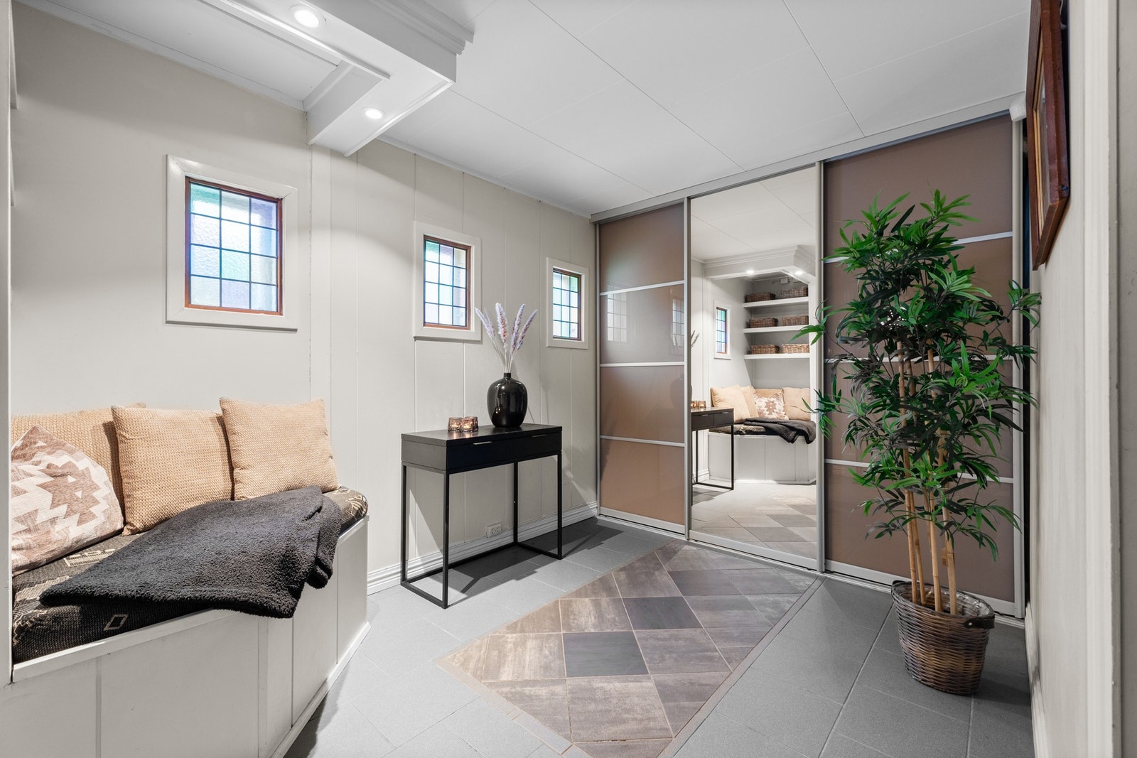 Praktisk, stor skyvedørsgarderobe og fliser på gulv Galleribilde