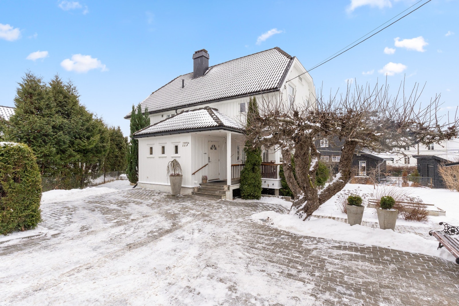 Romslig gårdsplass med belegningsstein og plass til flere biler Galleribilde