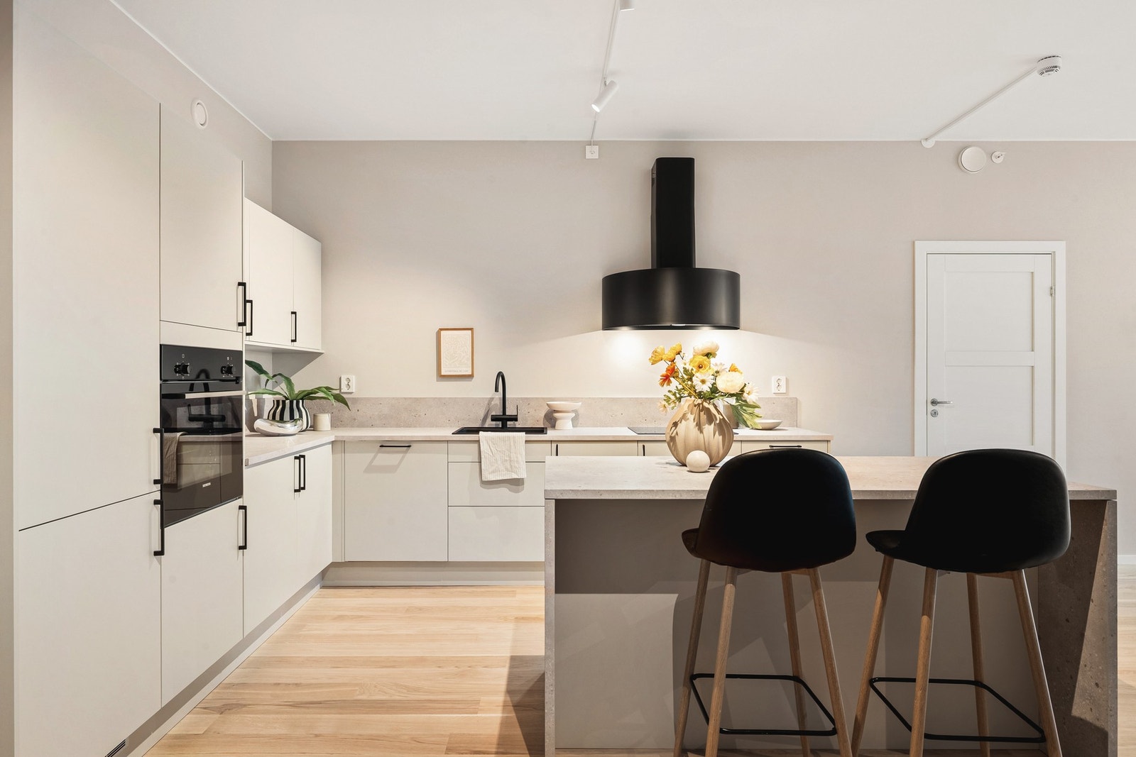 Innredningen består av slette fronter, sorte hådtak og detaljer, og benkeplate av laminat, som også beveger seg opp på veggen for beskyttelse av veggen under kokkeleringen. Galleribilde