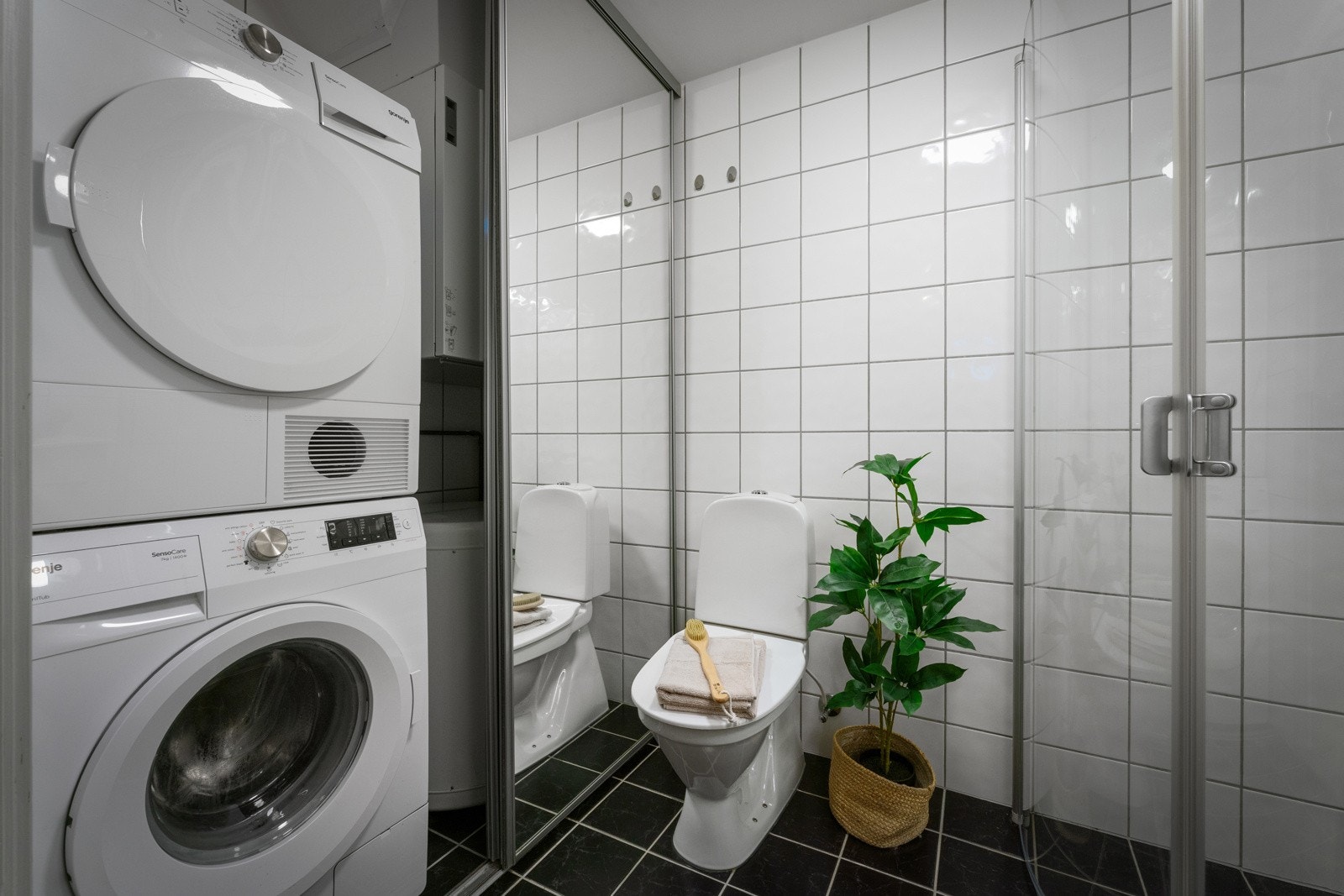 Badet er praktisk med plass til vaskemaskin og tørketrommel bak speilskyvedører Galleribilde