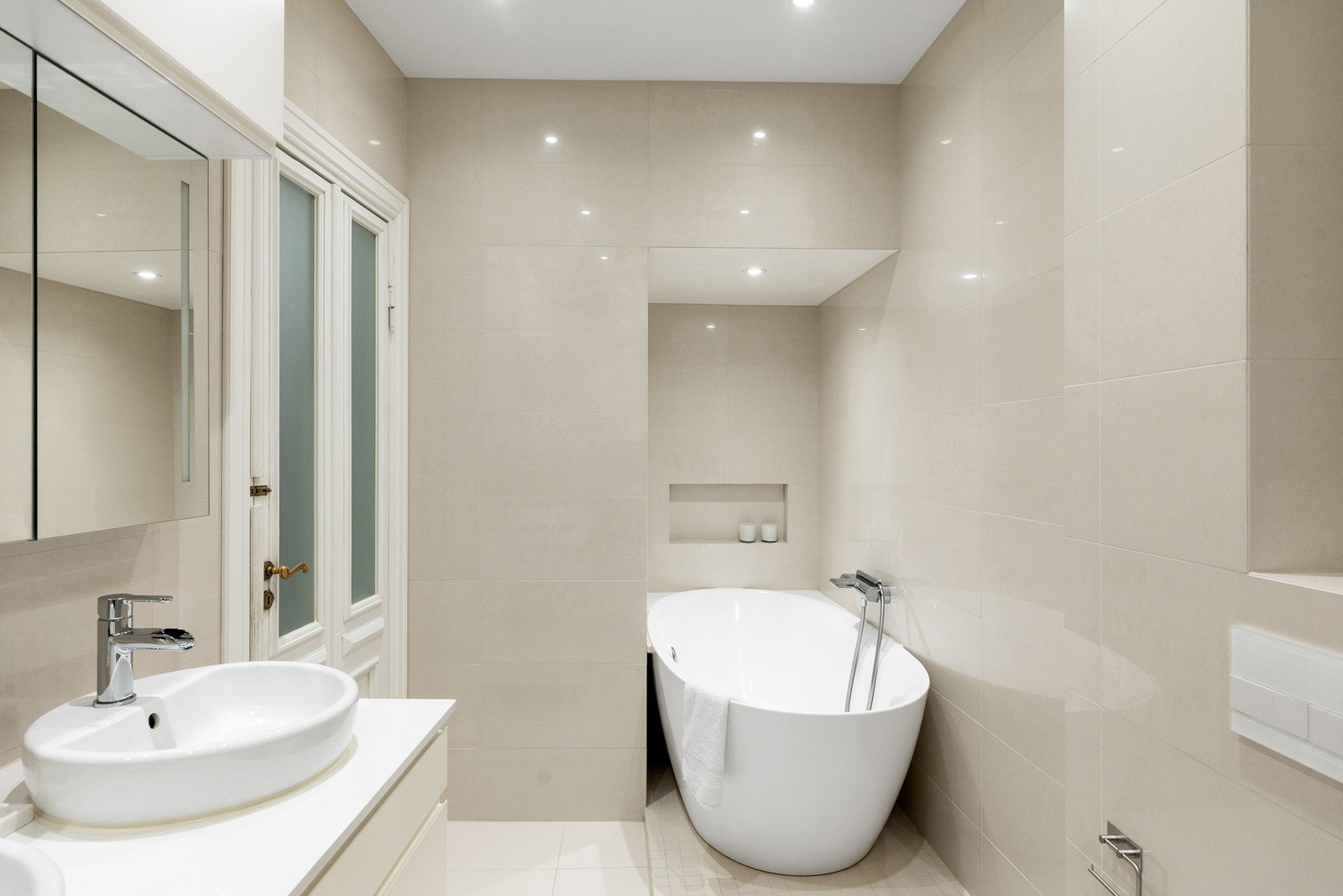 Innredningen består av servantskap med to toppservanter, veggskap med speildører og lys, vegghengt toalett, dusjsone med innfelte dusjdører samt badekar. Galleribilde