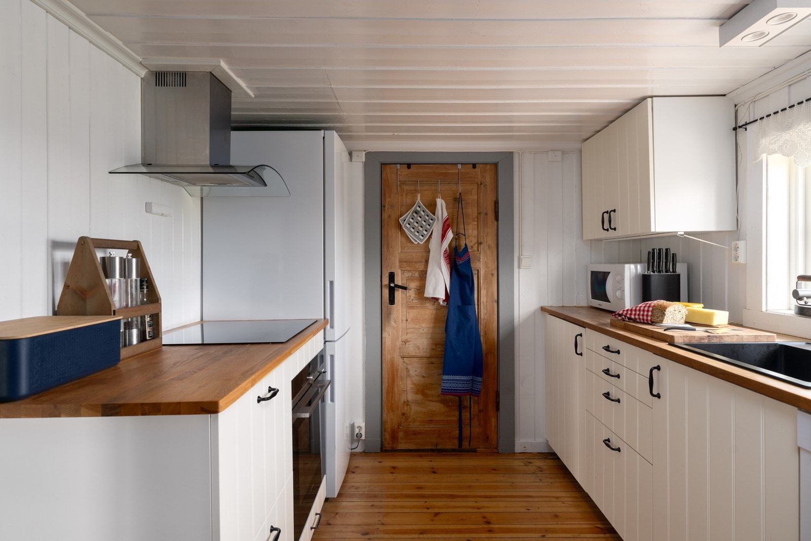 Innredningen har heltre benkeplate og profilerte fronter, integrerte hvitevarer samt frittstående kjøl/frys, og ventilator med avtrekk. Galleribilde