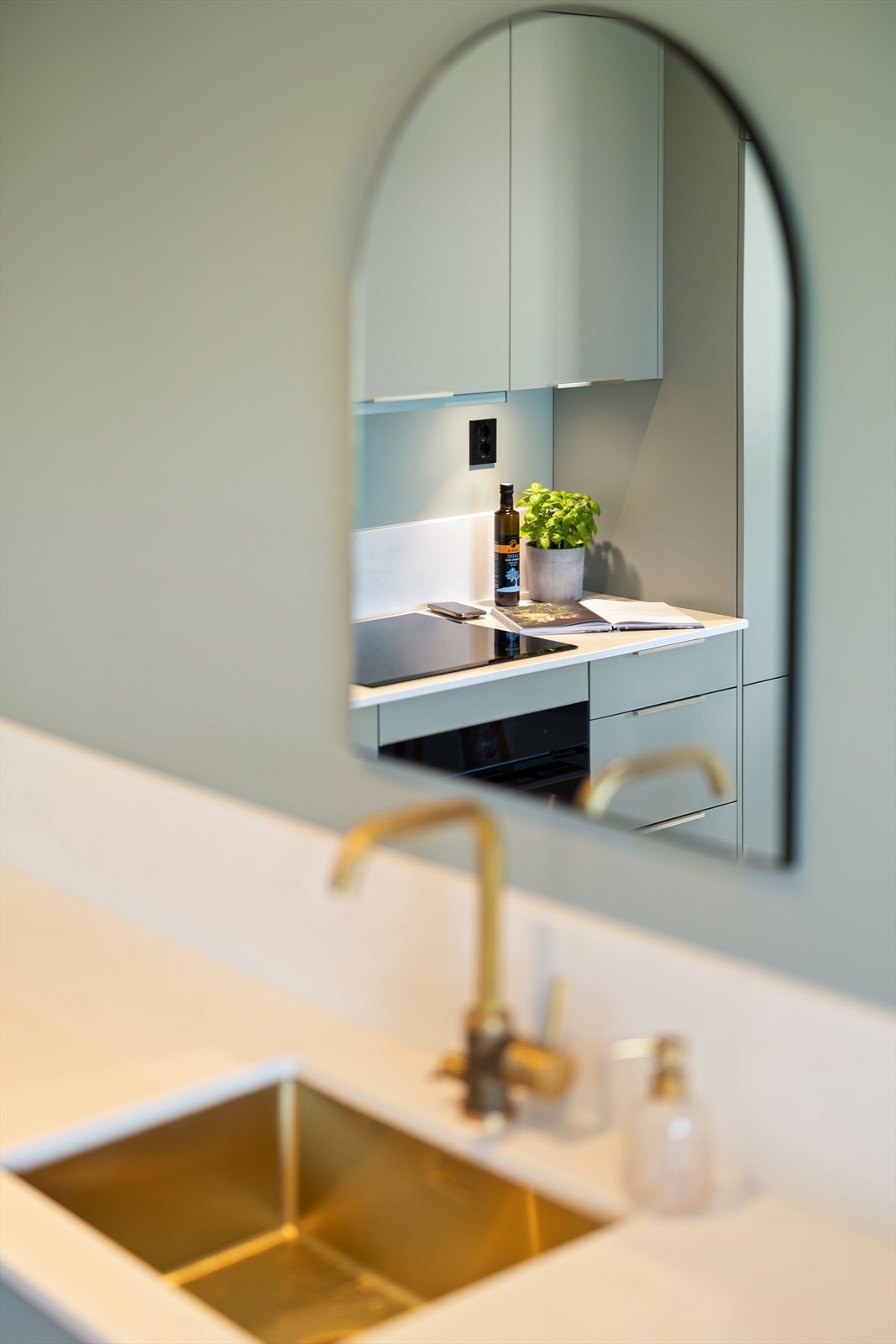 Delikate detaljer som blandebatteri i messing og lys benkeplate i stein. Galleribilde