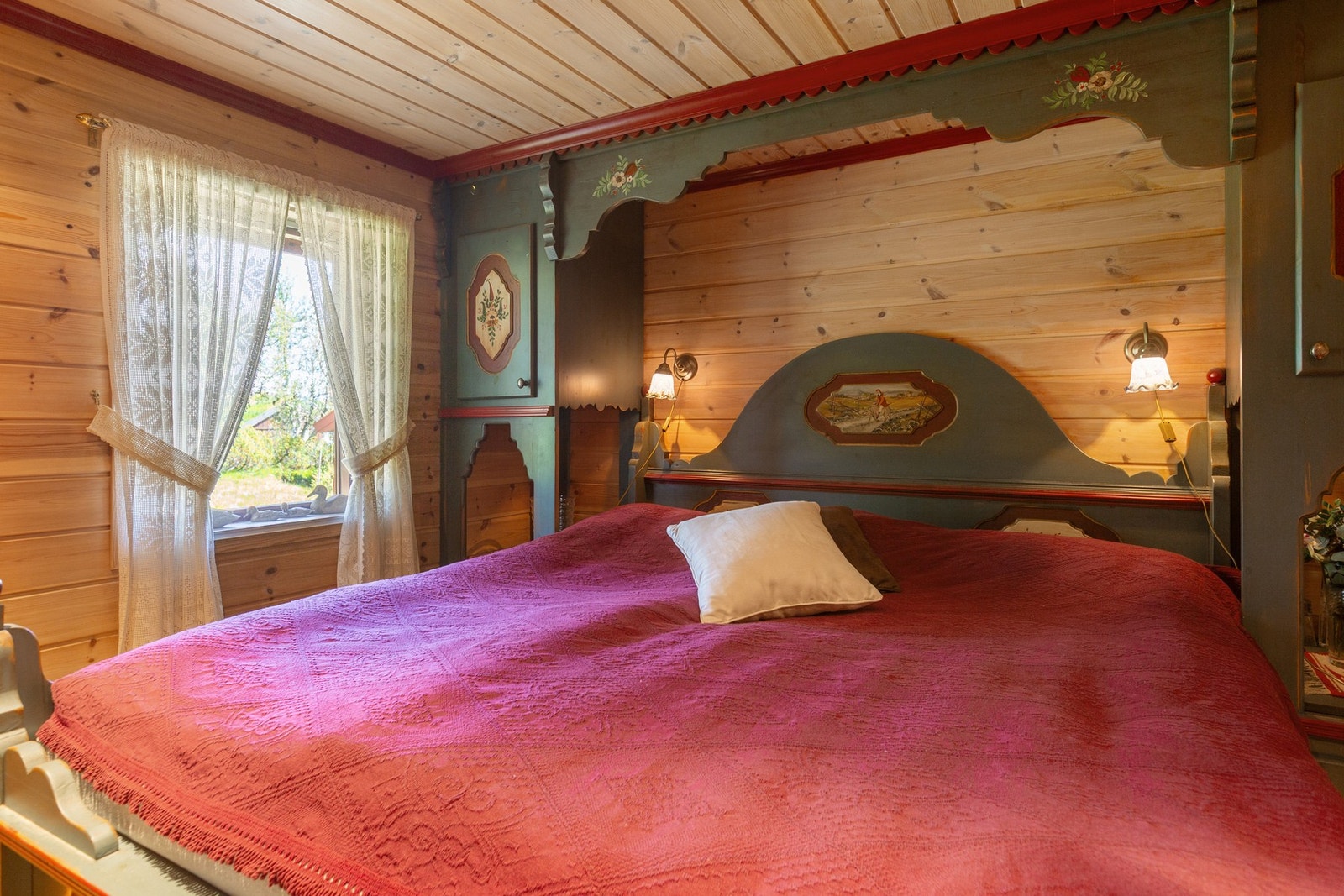 Hovedsoverom med plassbygd dobbeltseng med skuffer, skap med nattbord og garderobeskap av aldringsmalt heltre med malt motiv. Galleribilde